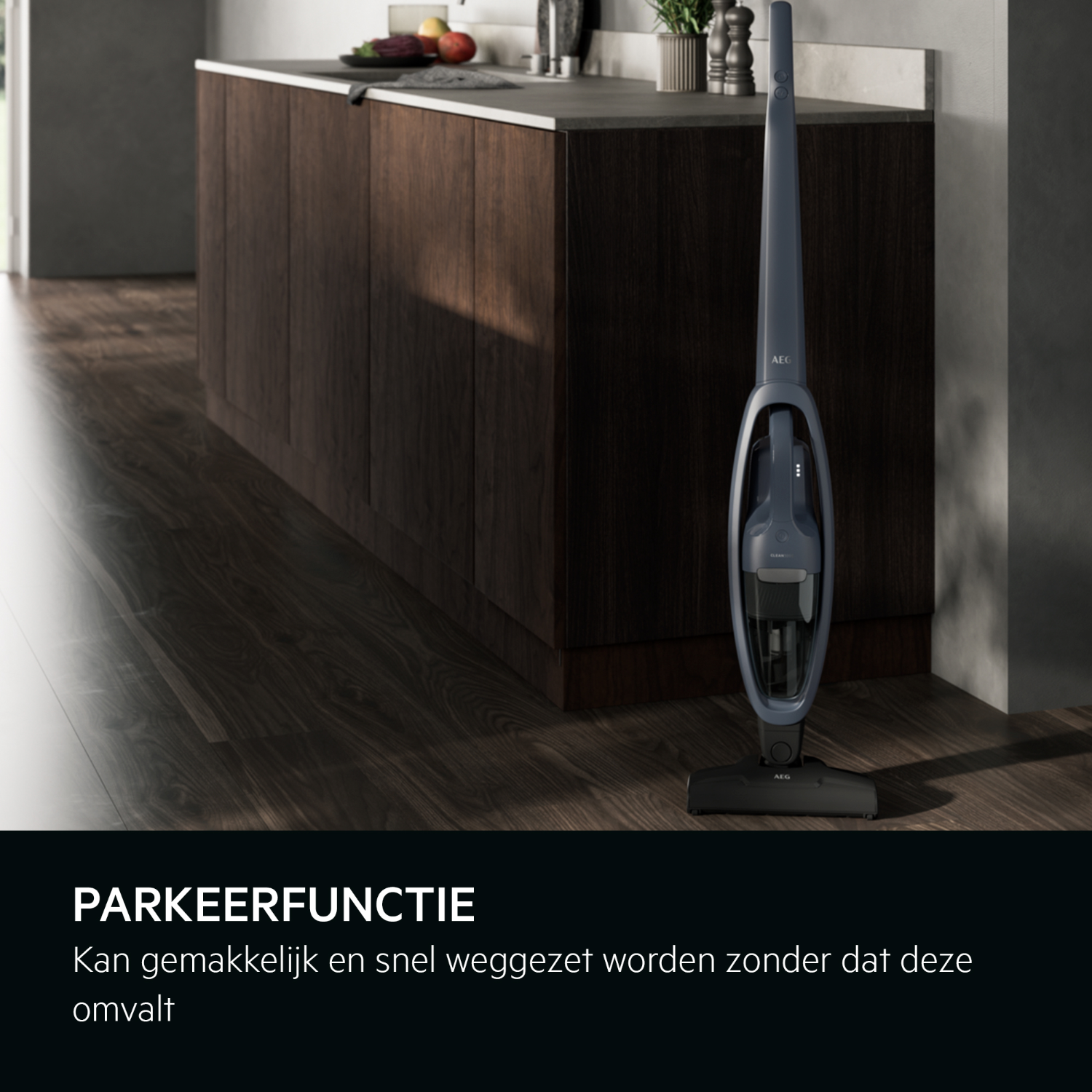 A dark blue cordless vacuum cleaner stands in a modern kitchen with dark wood cabinets and a light floor.