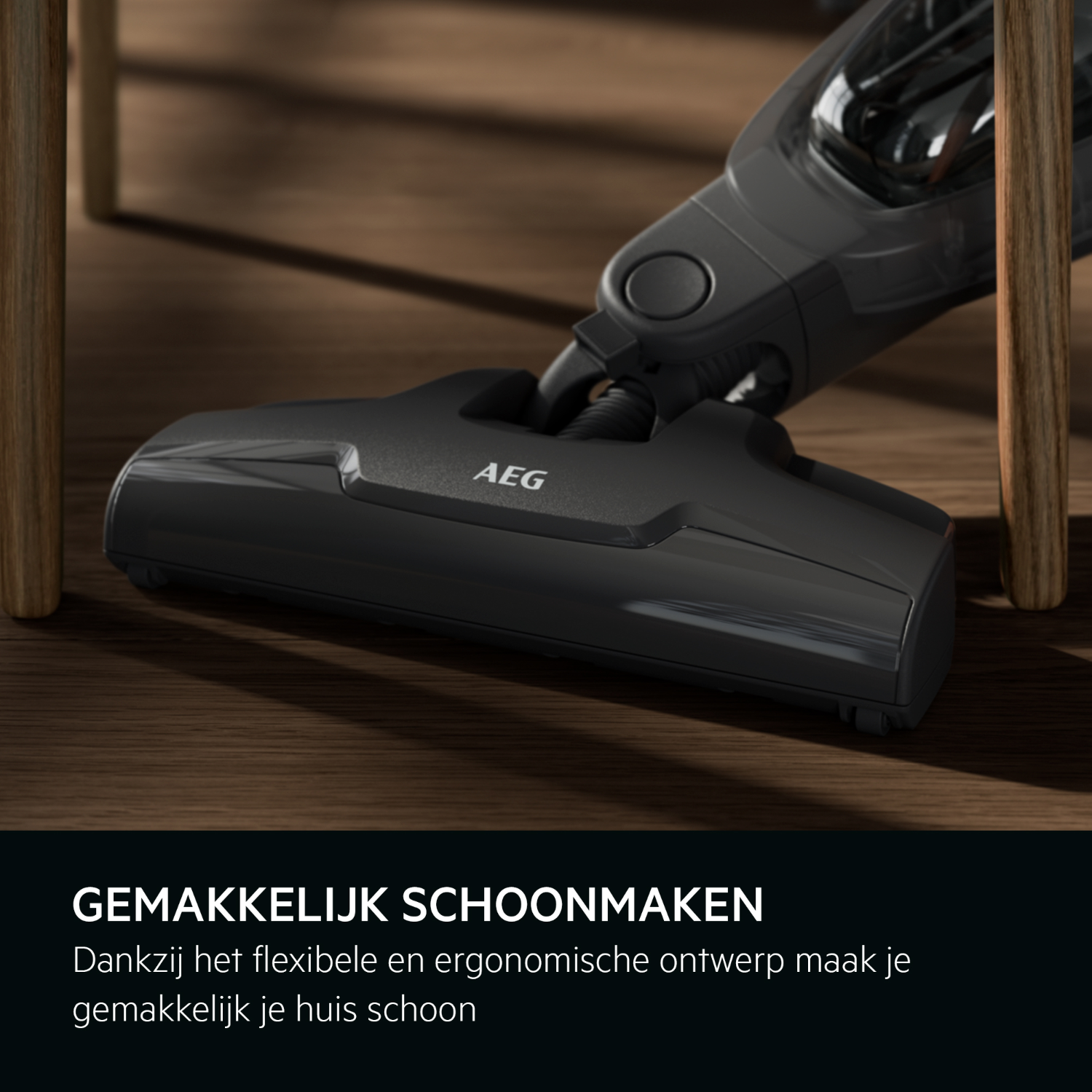 A black AEG vacuum cleaner on a wooden floor. The front part with the AEG logo is visible.
