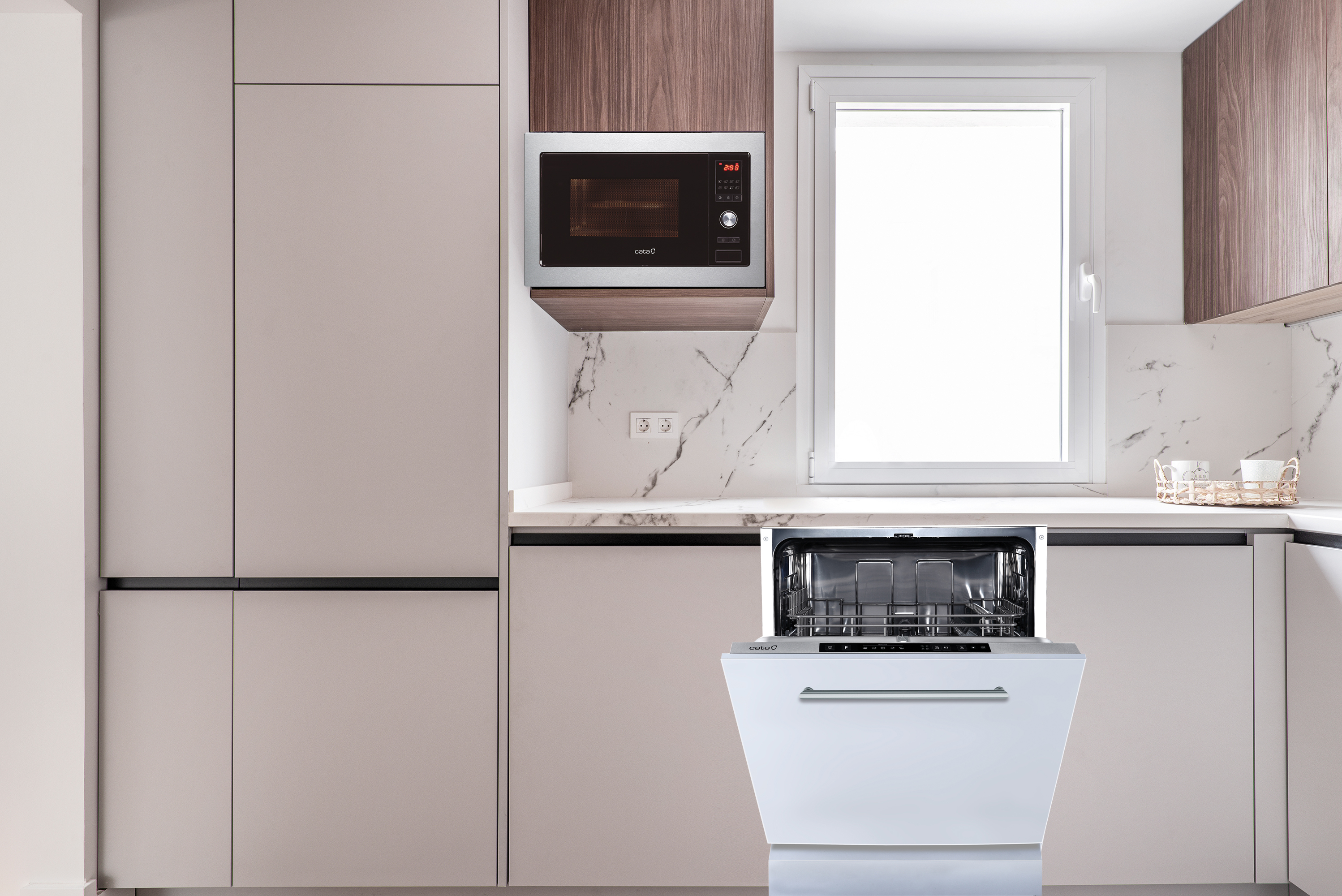 Escena de cocina: microondas, lavavajillas, armarios y ventana, colores neutros.