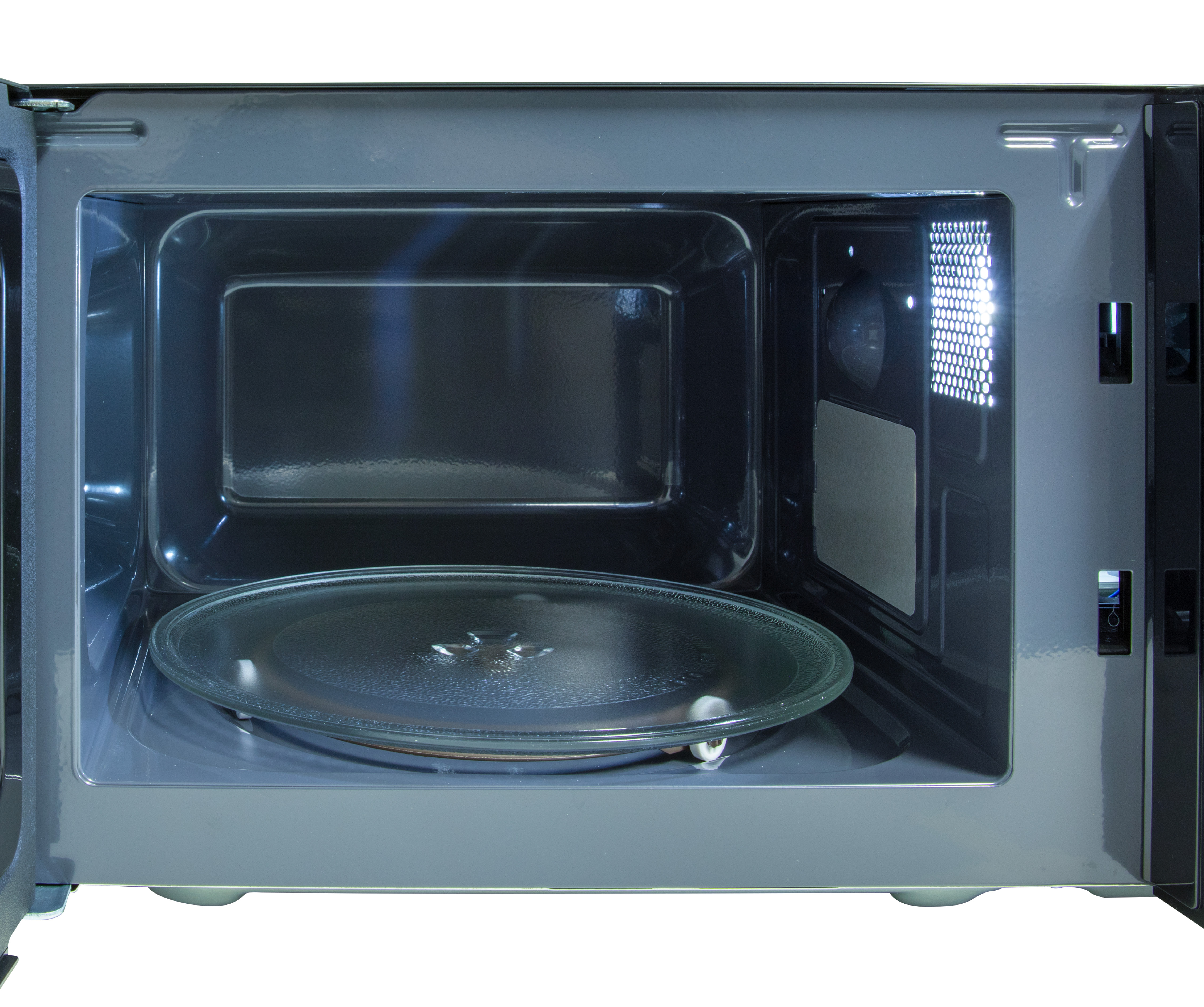 The inside of a microwave with a glass plate. The door is open, showing the interior.