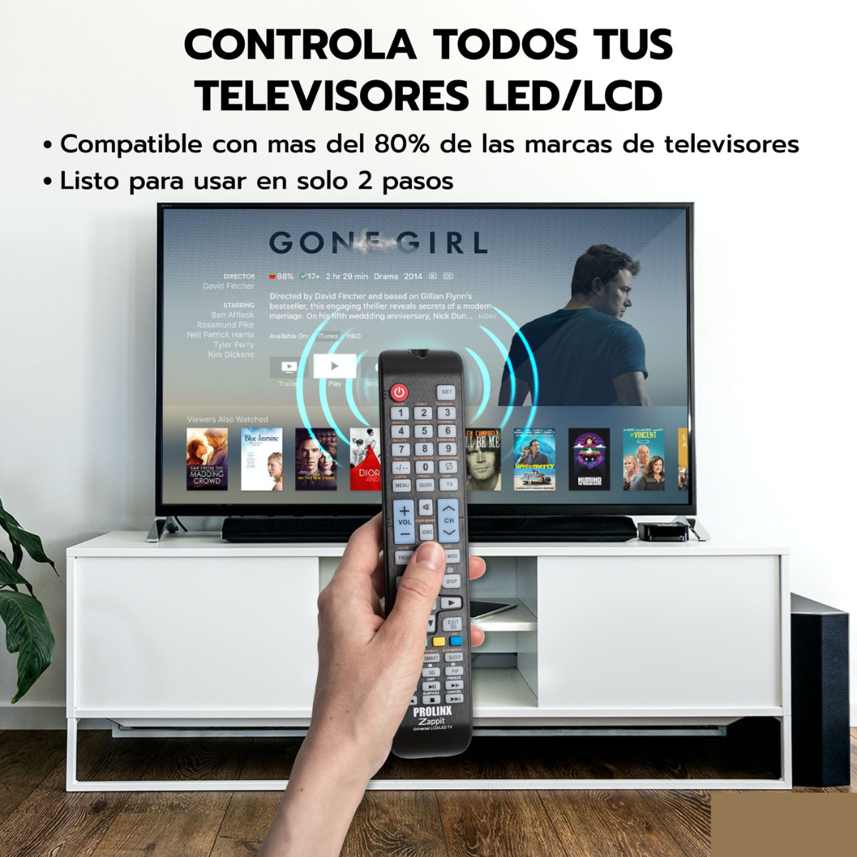 Mano sosteniendo control remoto, pantalla TV con título de película, mueble blanco, texto superpuesto.