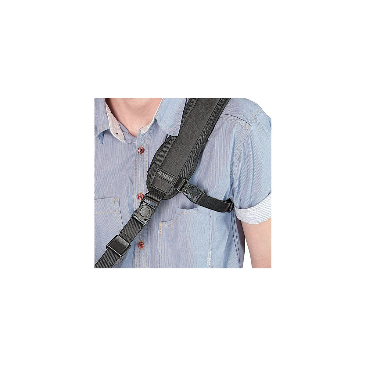 Mężczyzna w niebieskiej koszuli, czarny pasek do aparatu na ramieniu.