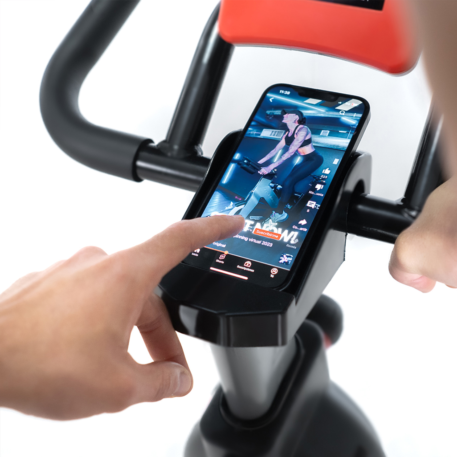 Persona usando un smartphone en una bicicleta estática, viendo un video de entrenamiento.