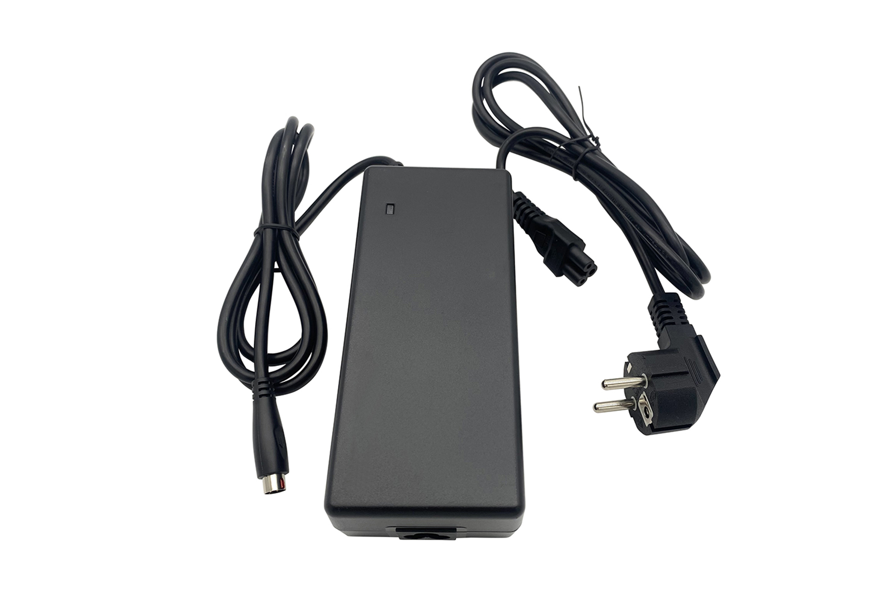 Schwarzer Netzadapter mit schwarzem Kabel und Stecker. Er liegt auf einer weißen Oberfläche.