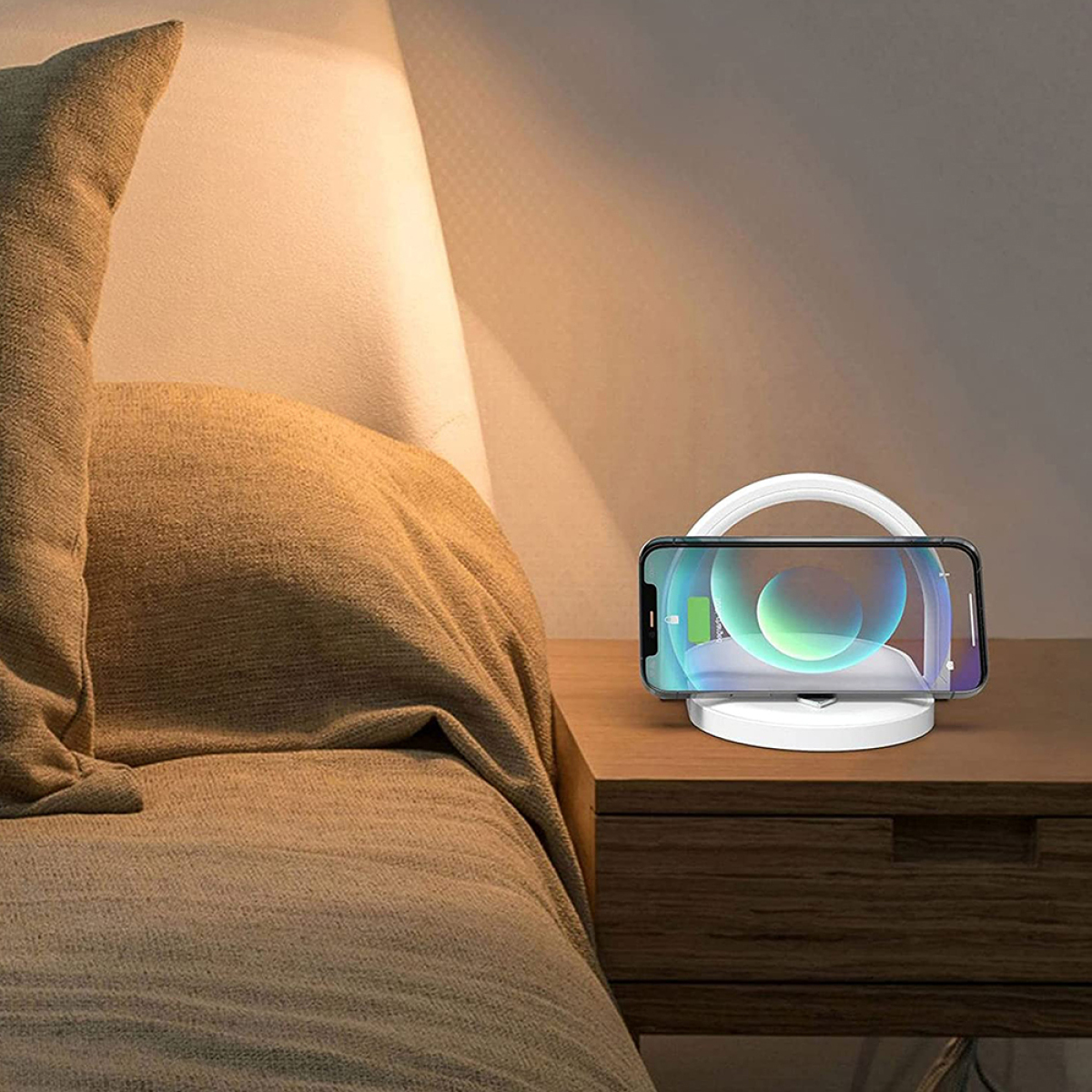 Ein Telefon auf einem kabellosen Ladegerät, auf einem Nachttisch neben einem Bett.