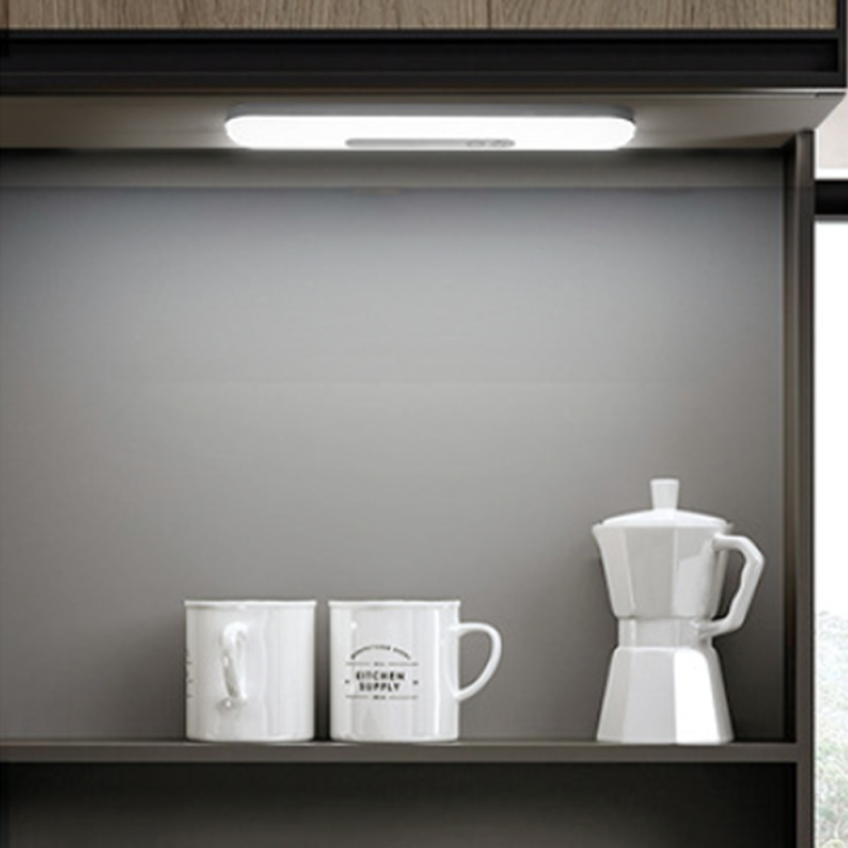 Regal mit Tassen, Kaffeekanne und Licht. Grauer Hintergrund, weiße Gegenstände.