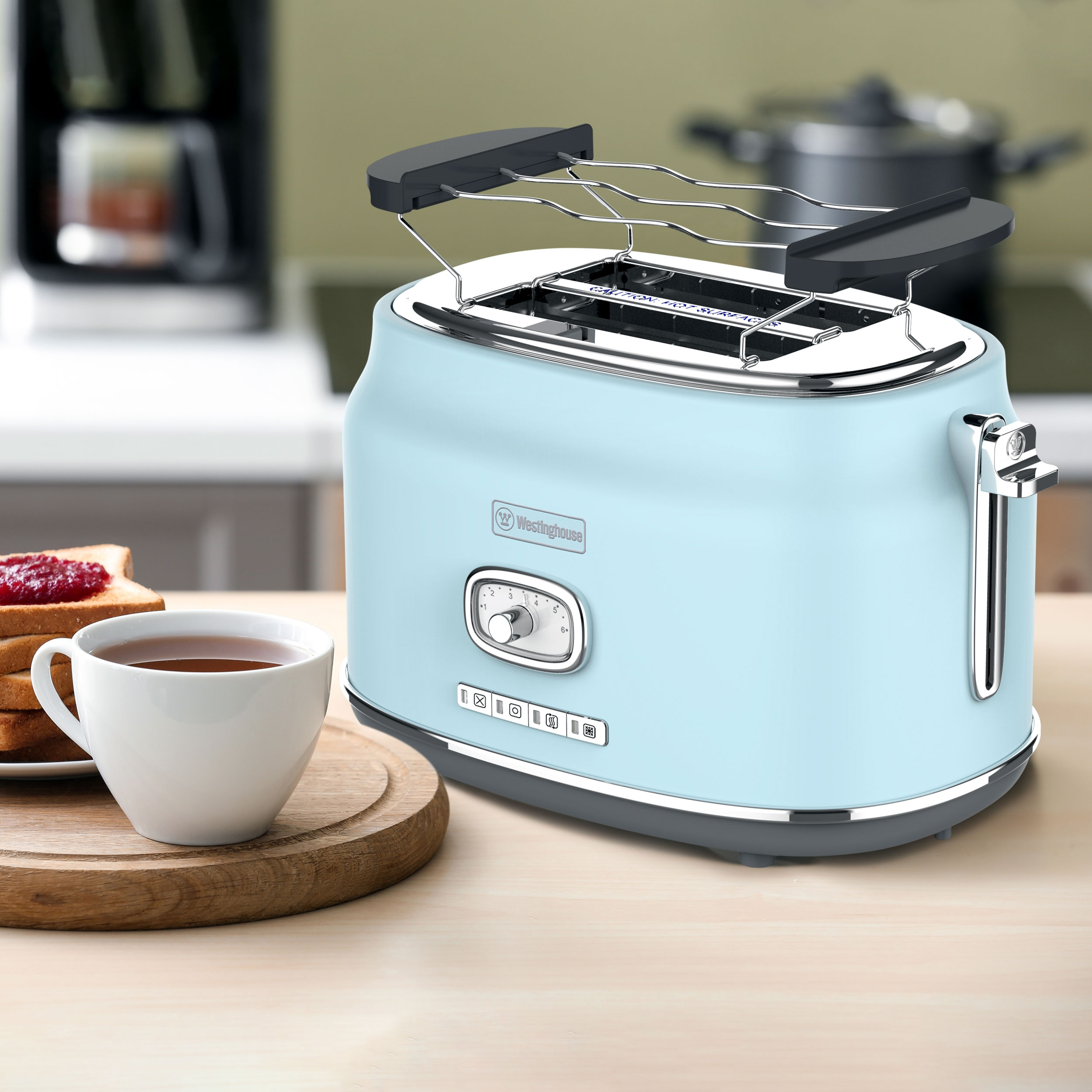 Ein blauer Westinghouse-Toaster, Toast, Marmelade und eine Tasse Tee auf einem Holzbrett.