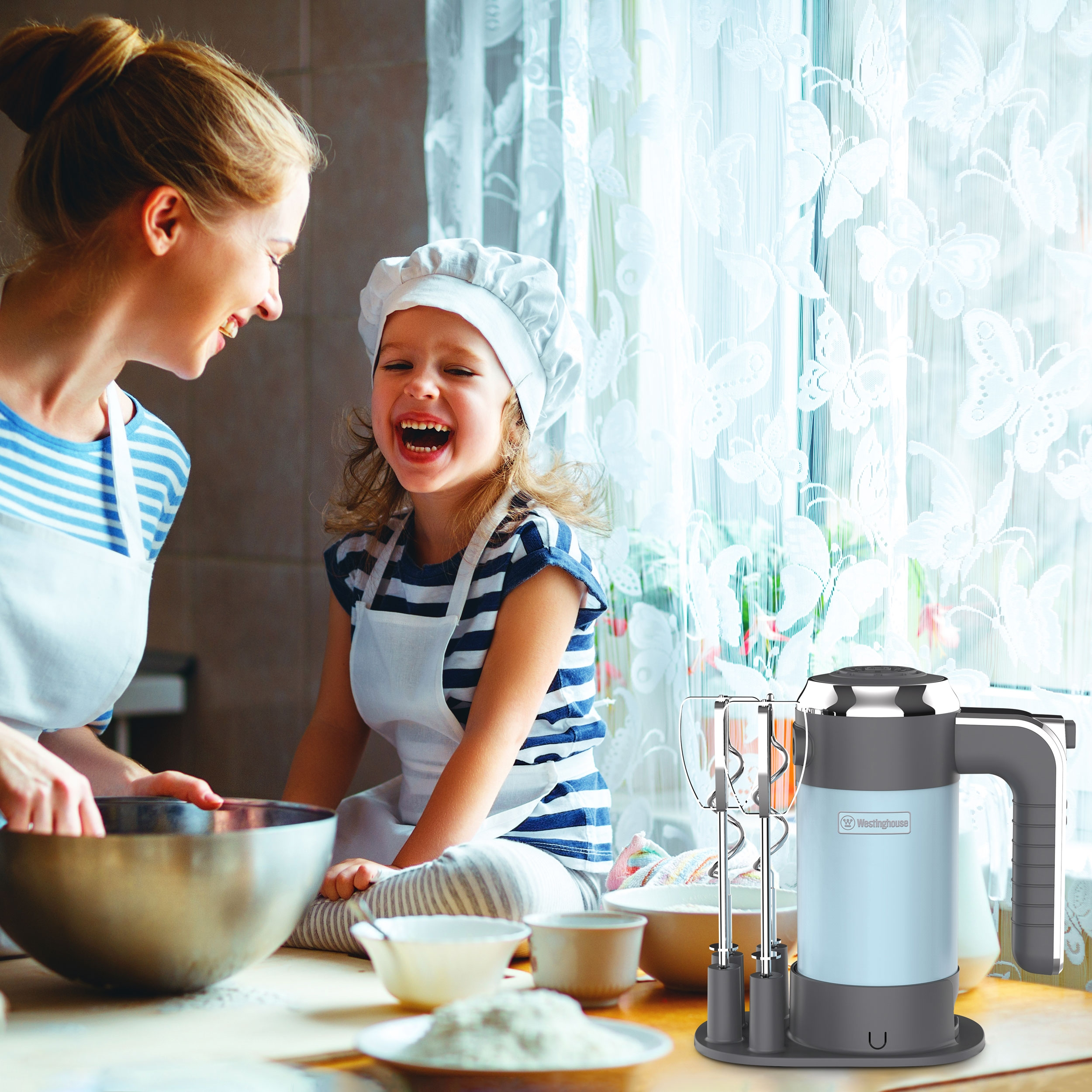 Eine Frau und ein Kind lachen beim Backen, rechts ist ein Mixer zu sehen.