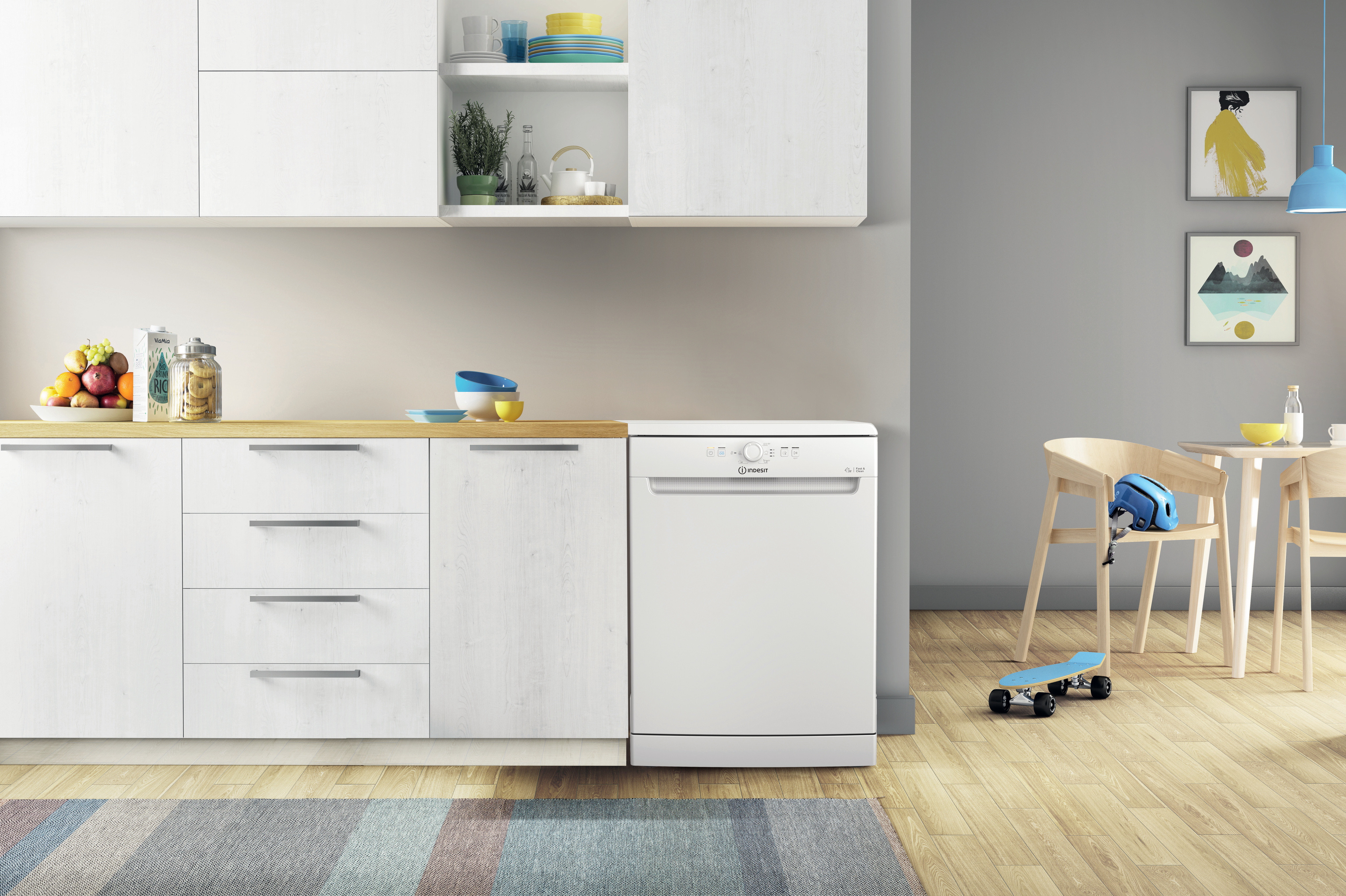 Cocina con lavavajillas, armarios y encimera. También hay una mesa y sillas.