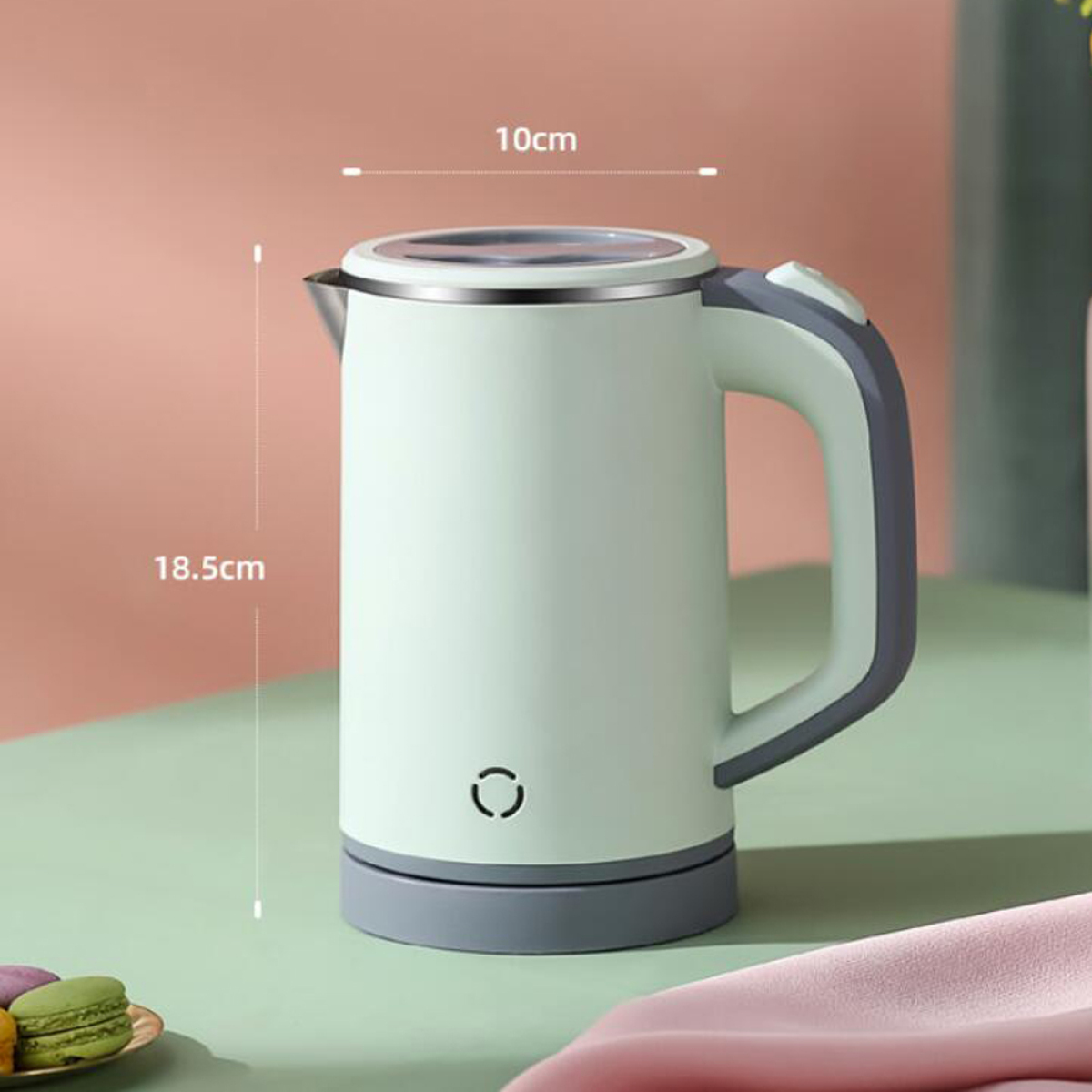 Ein hellgrüner elektrischer Wasserkocher mit Abmessungen in cm, mit grauem Sockel und Griff.