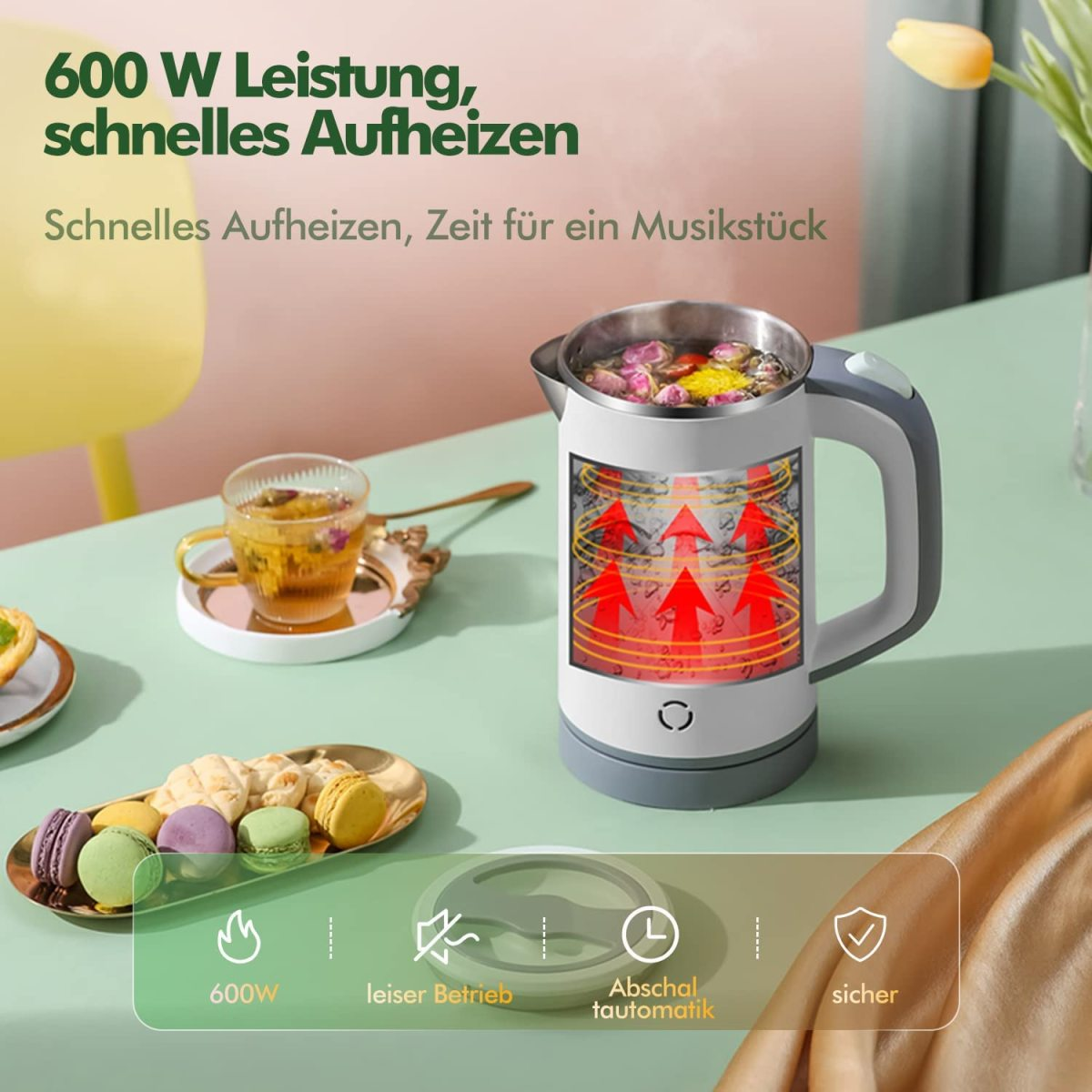 Kleiner elektrischer Wasserkocher mit Essen, auf einem Tisch mit anderem Essen und Tee.