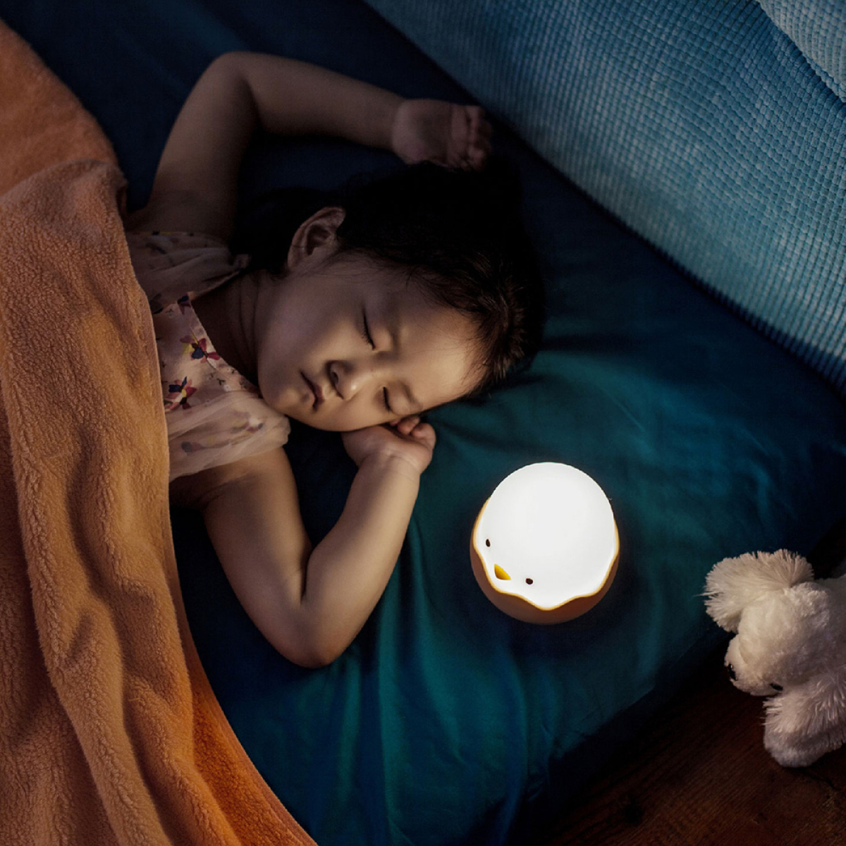Ein schlafendes Kind neben einem nachtlichtförmigen Ei.