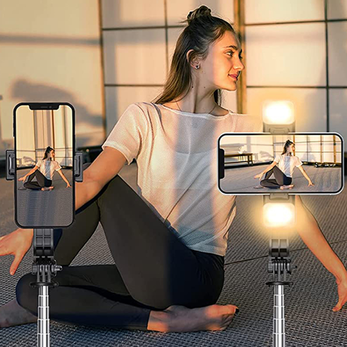 Eine Frau macht Yoga, mit zwei Telefonen, die die gleiche Pose zeigen. Lichter sind an.