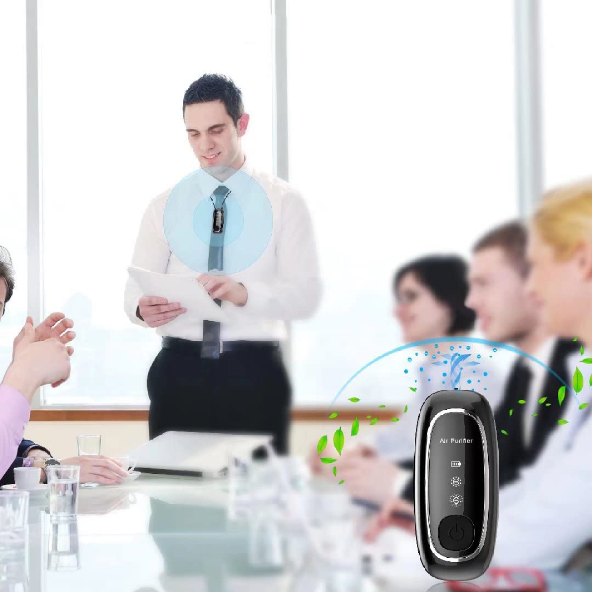 Ein Mann in weißem Hemd spricht in einem Meeting und hält Papiere. Ein Luftreiniger im Vordergrund.