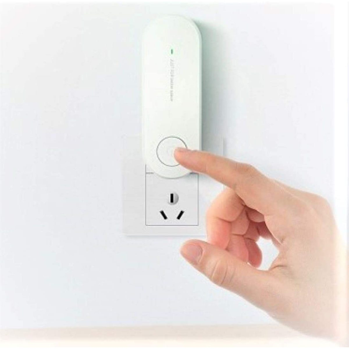 Weißer Plug-in-Luftreiniger mit Finger, der auf den Knopf drückt. Die Steckdose ist ebenfalls sichtbar.