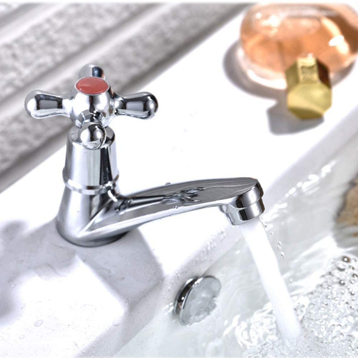 Chrom-Wasserhahn mit fließendem Wasser. Rote und silberne Details. Weißes Waschbecken.