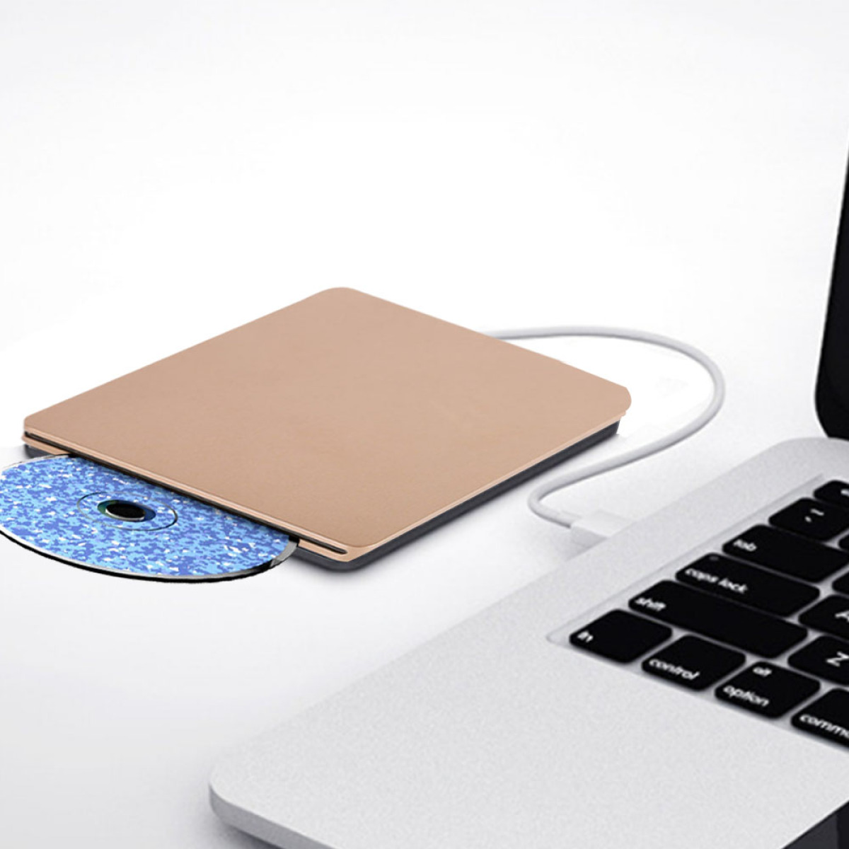 Externes CD-Laufwerk mit eingelegter CD, an einen Laptop angeschlossen. Weißer Hintergrund.