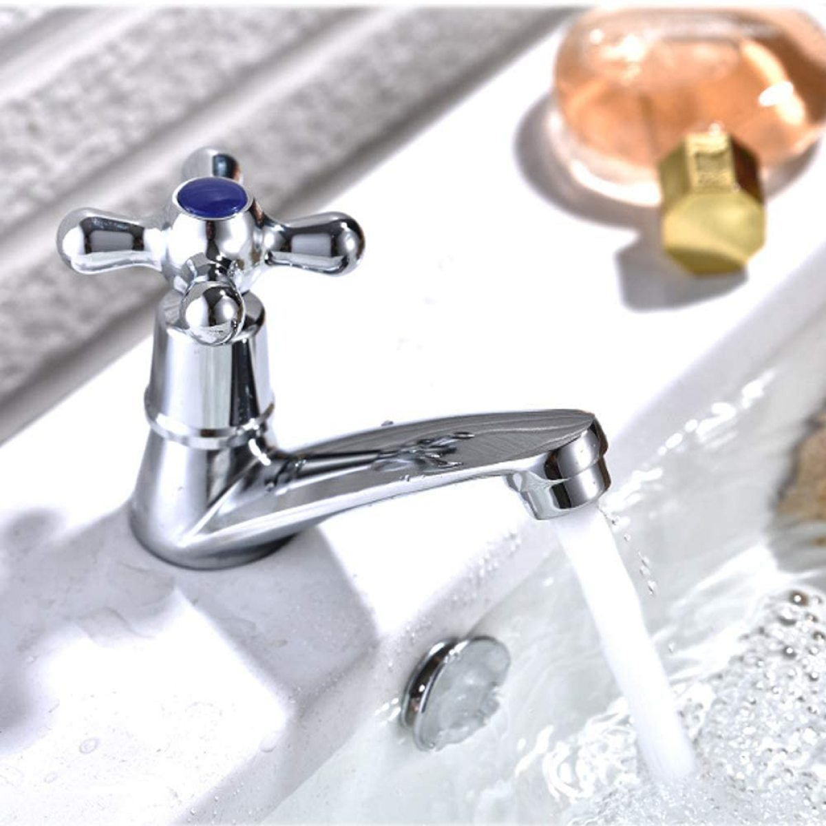Chrom-Wasserhahn in einem weißen Waschbecken, Wasser fließt.