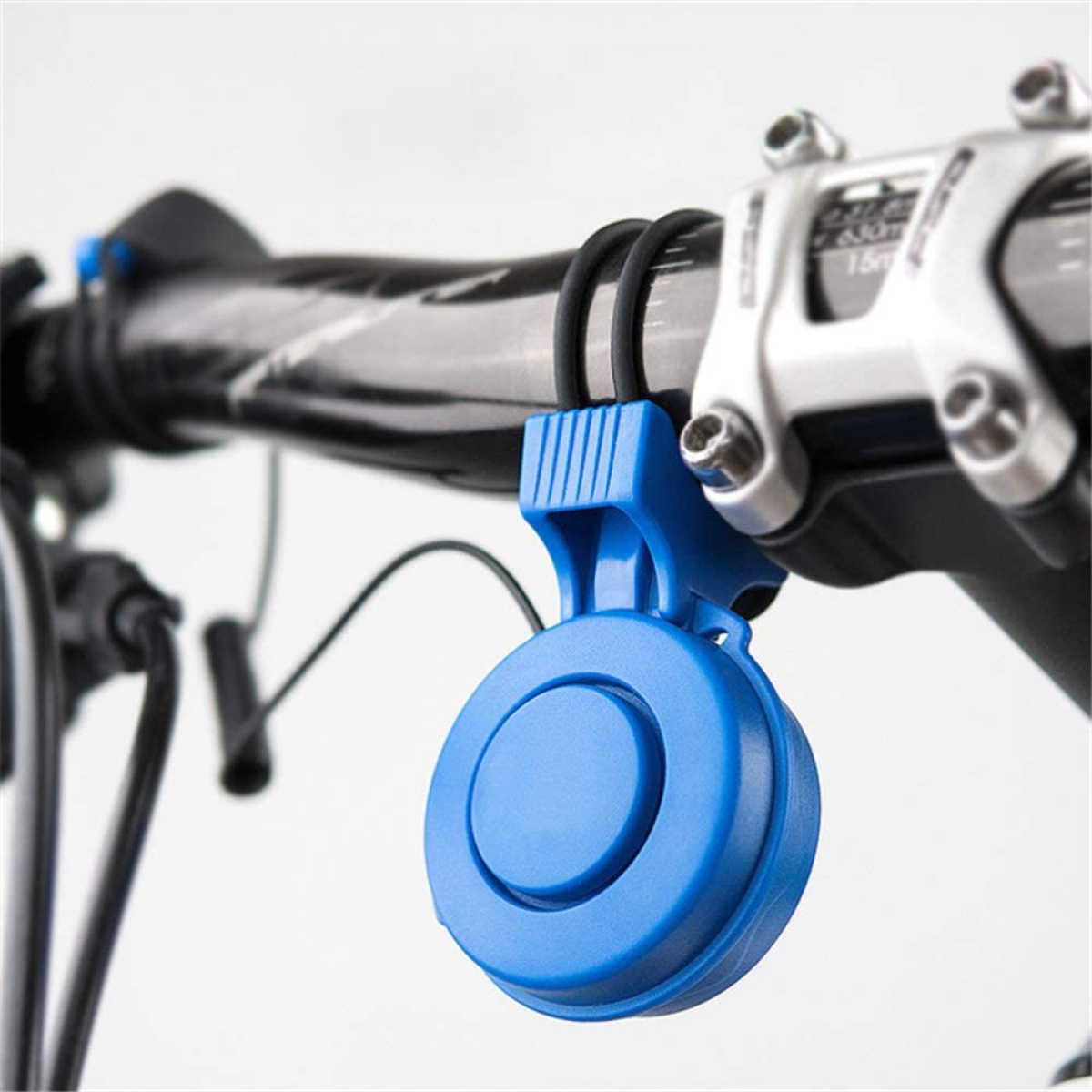 Eine blaue Fahrradklingel an einem Fahrradlenker vor weißem Hintergrund.