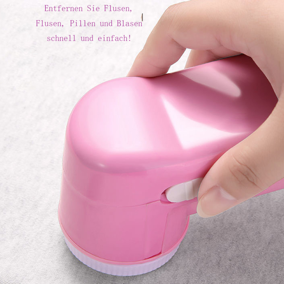 Ein pinkfarbener Stoffrasierer. Eine Hand hält das Gerät.