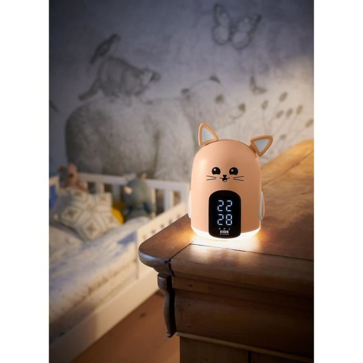 Una luz nocturna con forma de gato y reloj digital muestra la hora. Una cama en el fondo.