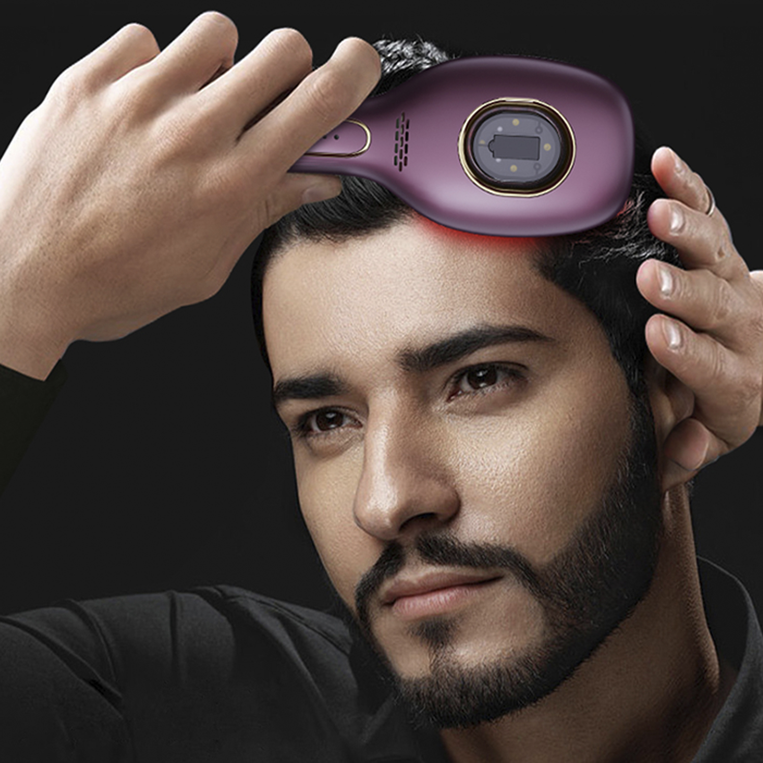 Un hombre usa un dispositivo púrpura para tratar el cabello, luz roja visible.