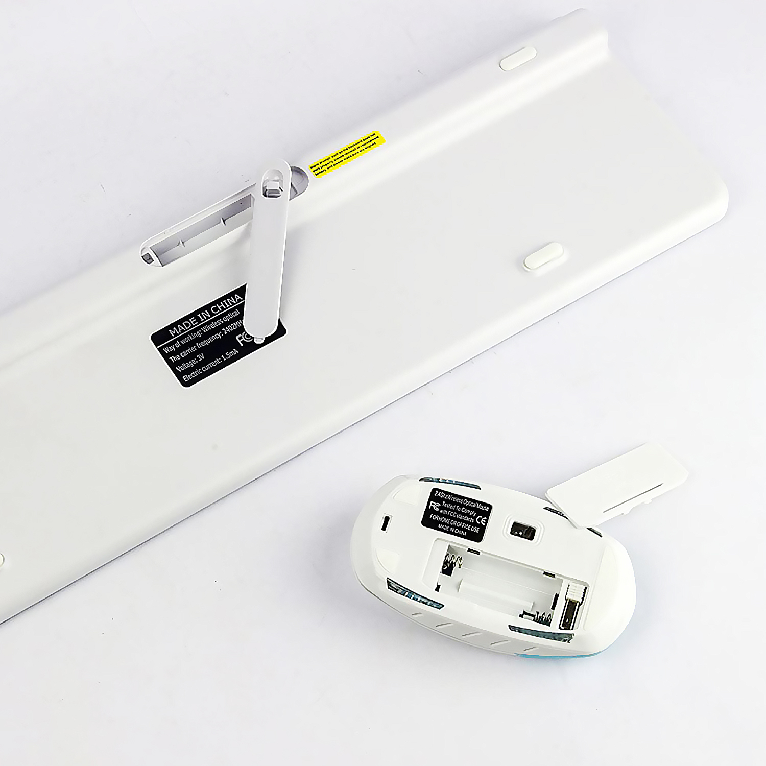 Parte trasera de un teclado blanco y un ratón blanco.