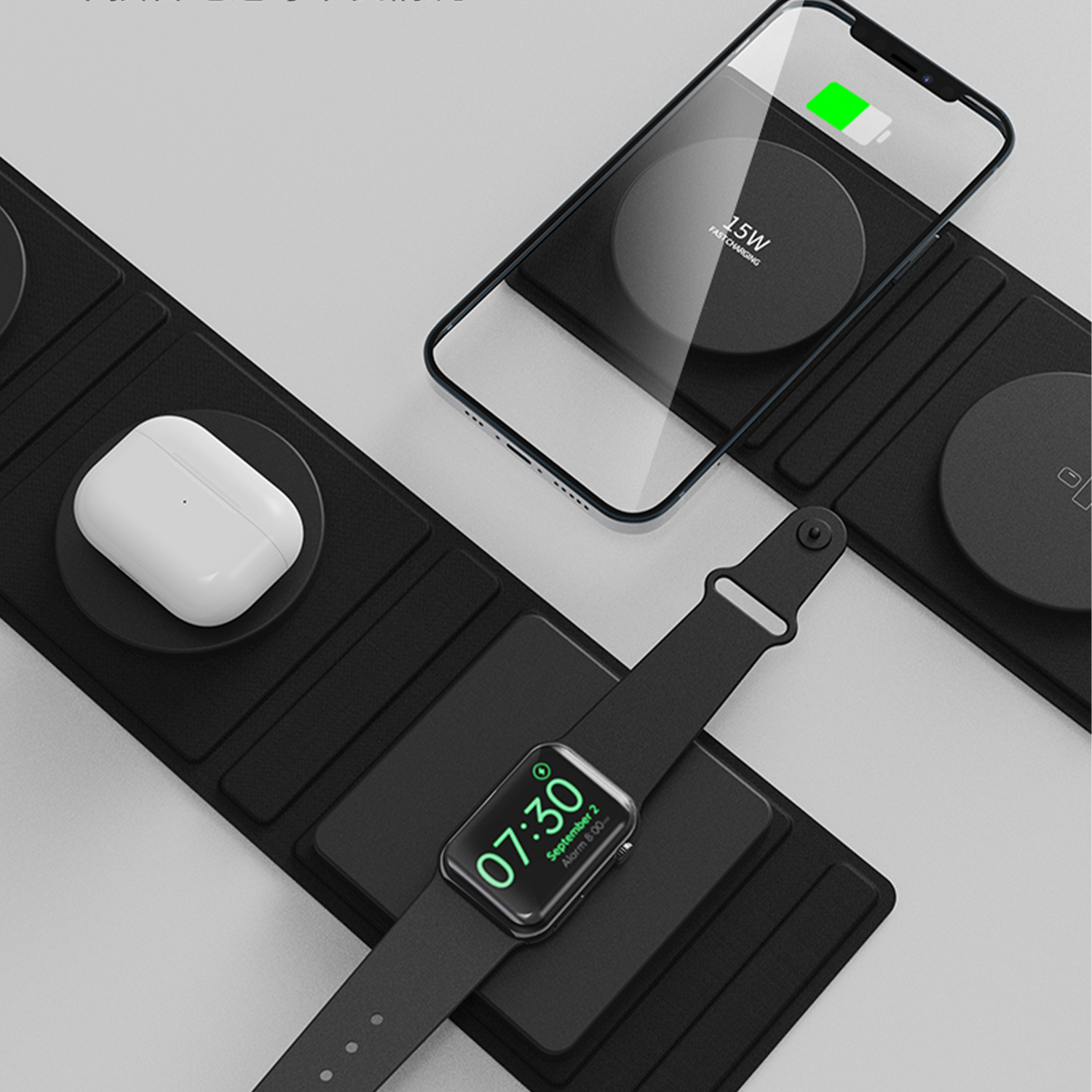 Base di ricarica wireless con telefono, orologio e auricolari in carica simultaneamente. Sfondo nero.