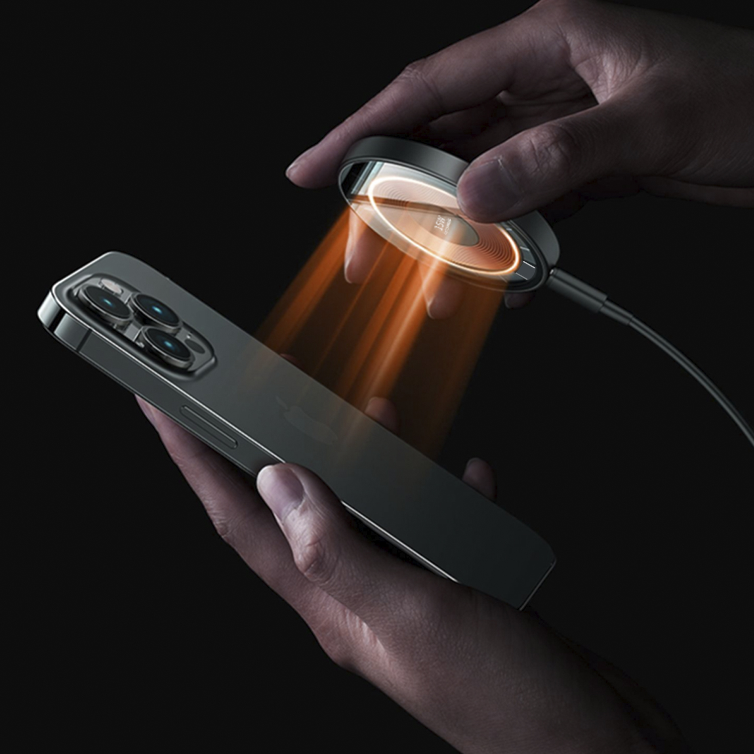 Mani che tengono un telefono e un caricatore wireless. La luce arancione brilla sul telefono.