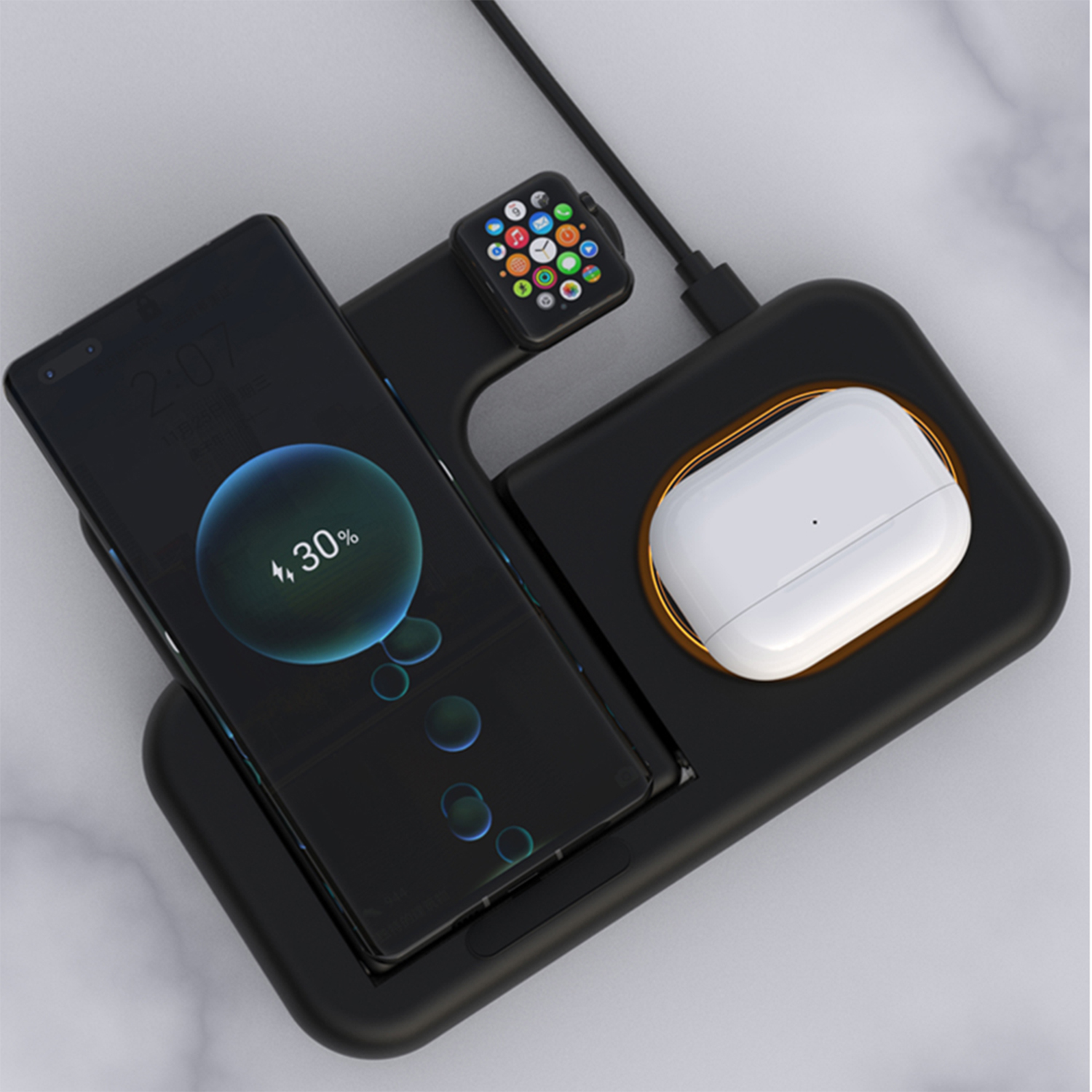 Stazione di ricarica nera con telefono, smartwatch e auricolari. Lo schermo del telefono mostra l'avanzamento della carica.