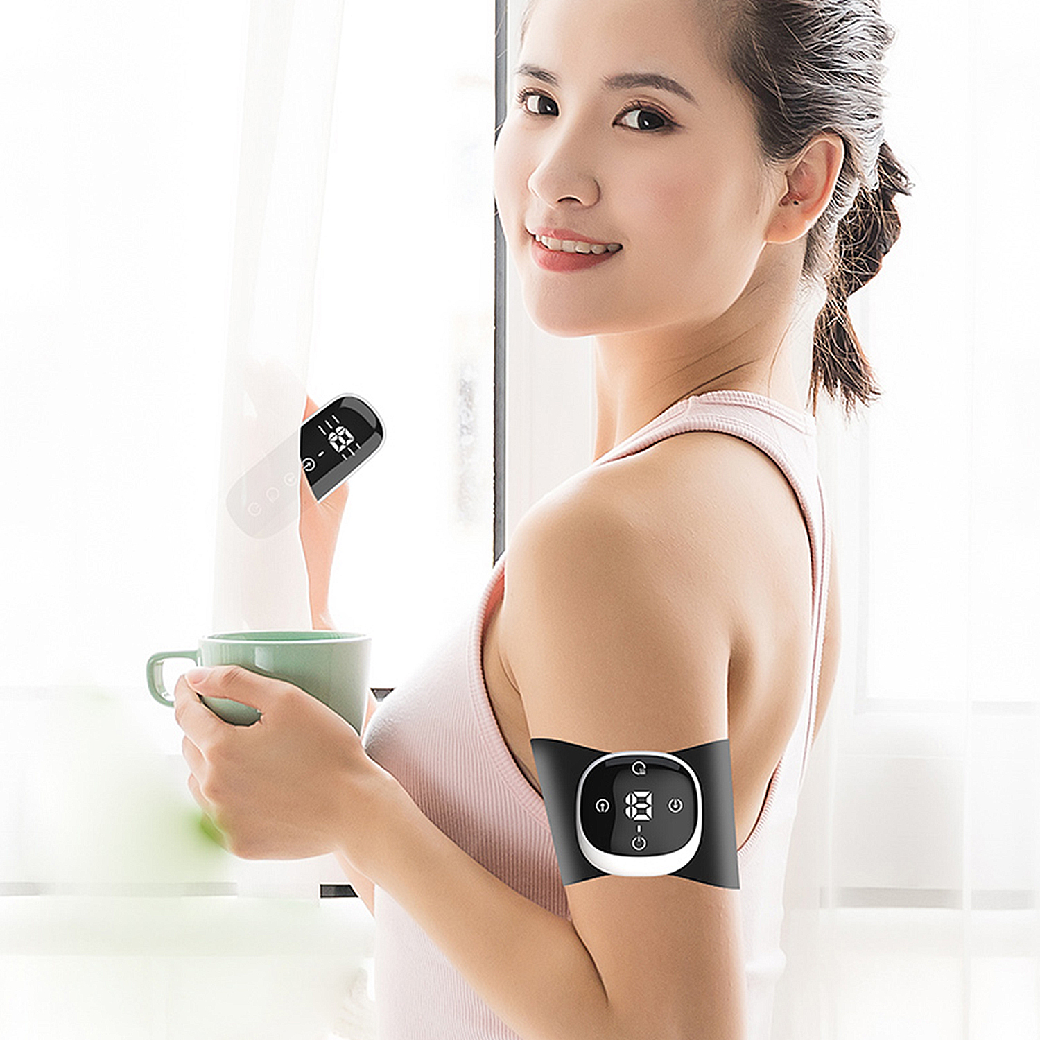 Una donna con un dispositivo sul braccio e un secondo in mano, che tiene una tazza.