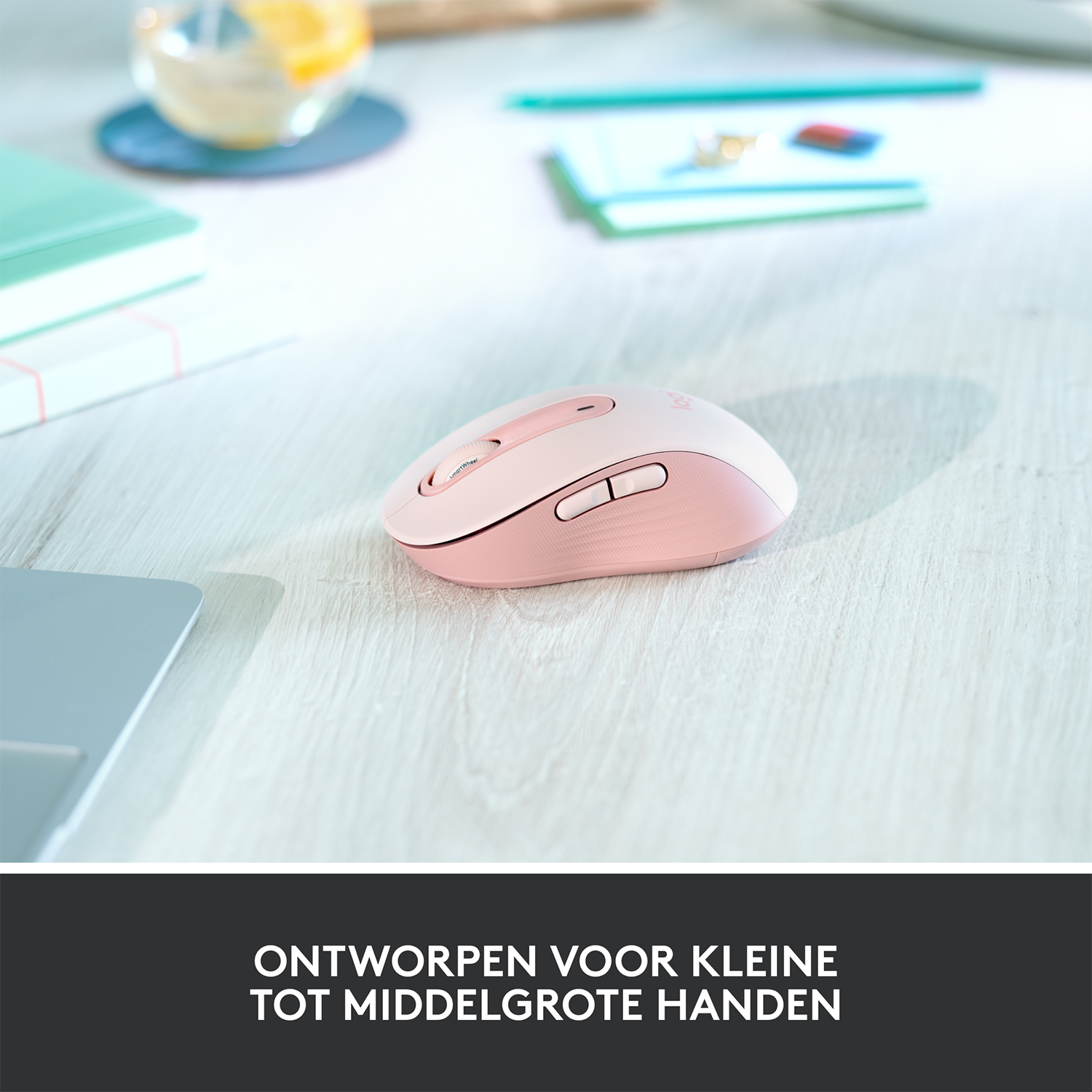 Różowa mysz komputerowa na drewnianym stole. Tekst: Zaprojektowany dla małych i średnich dłoni.