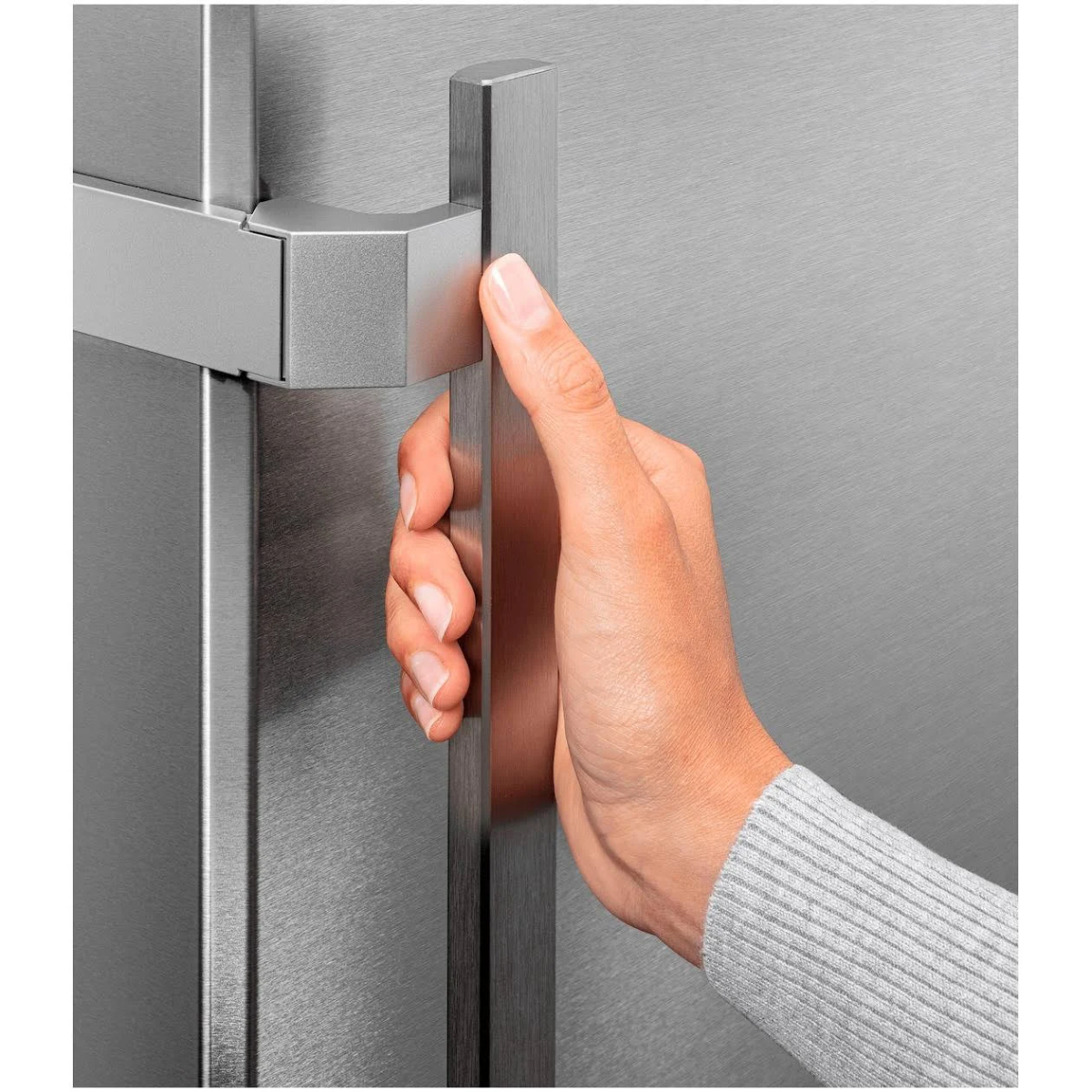 Hand opening a refrigerator door, showing the handle and a silver-colored refrigerator.