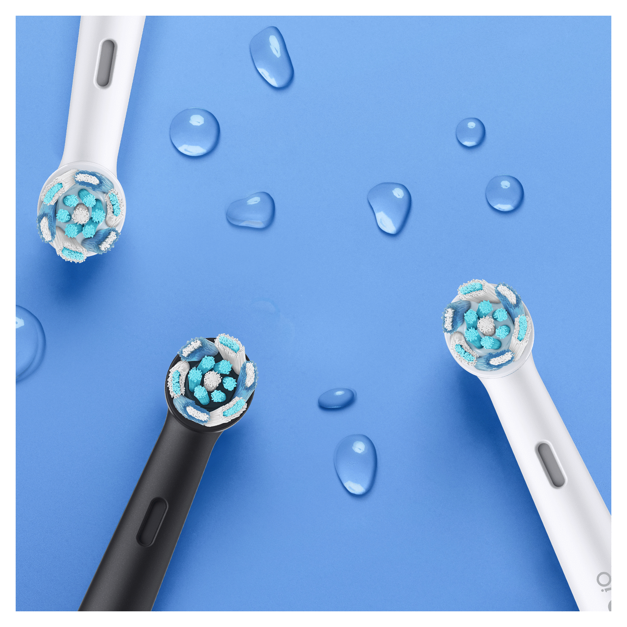 Trzy głowice szczoteczki elektrycznej z niebiesko-białym włosiem, wokół krople wody.