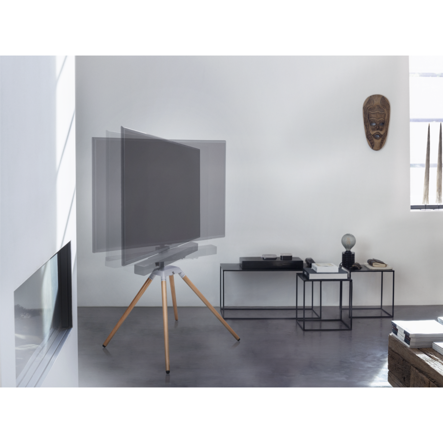 Moderne woonkamer met een draaiende tv op een houten statief, minimalistische inrichting.