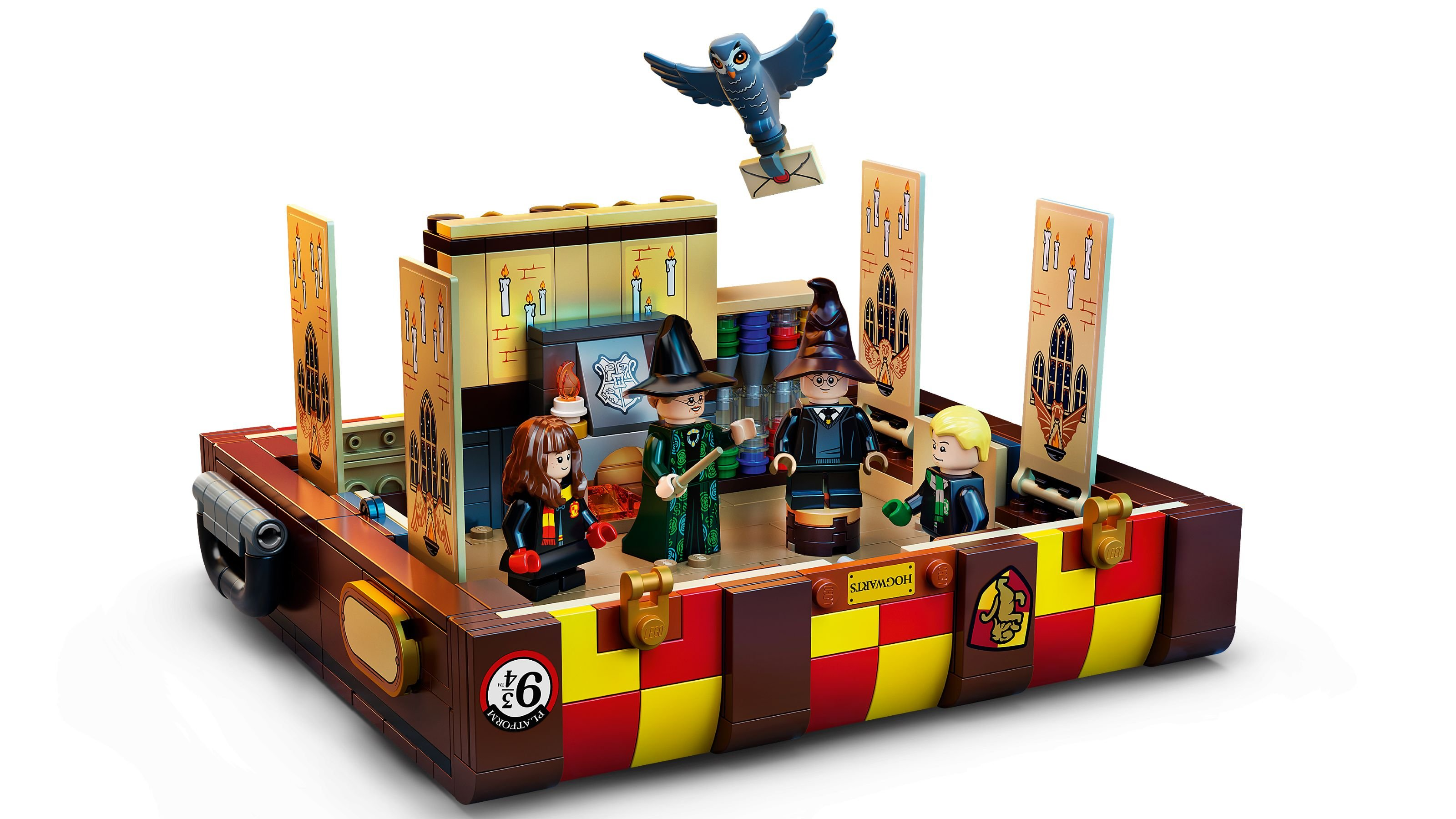 Lego-Set mit Hogwarts-Charakteren, Eule und Details von Gleis 9 3/4. Enthält Minifiguren und eine detaillierte Innenszene mit Kerzen.