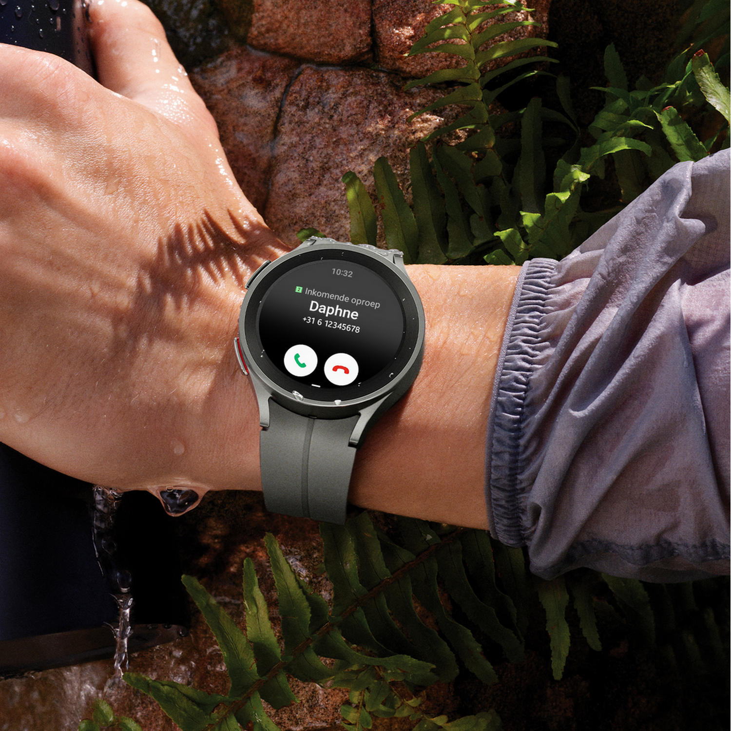 Una persona che indossa uno smartwatch al polso. L'orologio mostra i dettagli della chiamata in arrivo.
