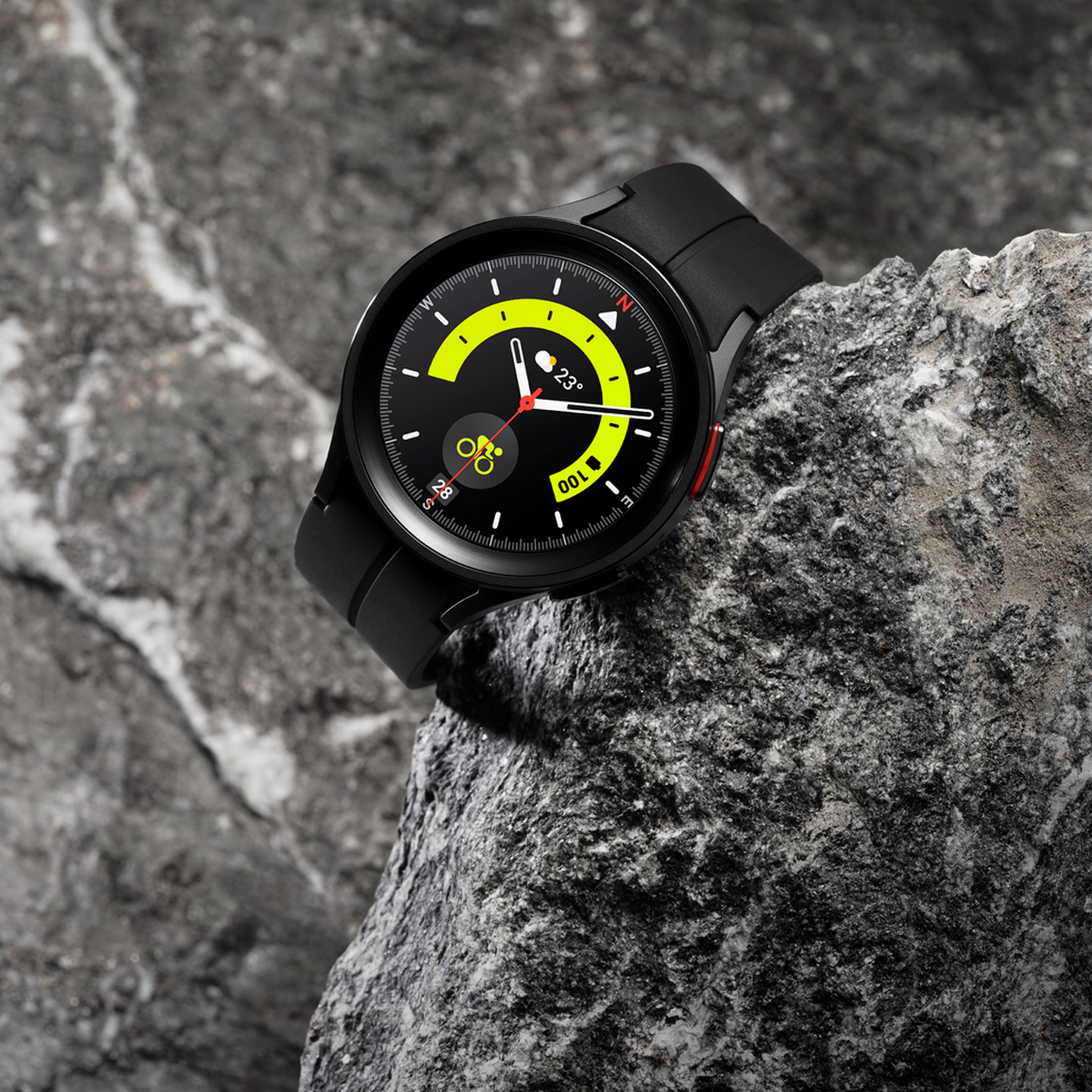 Smartwatch nero su una superficie rocciosa grigia.