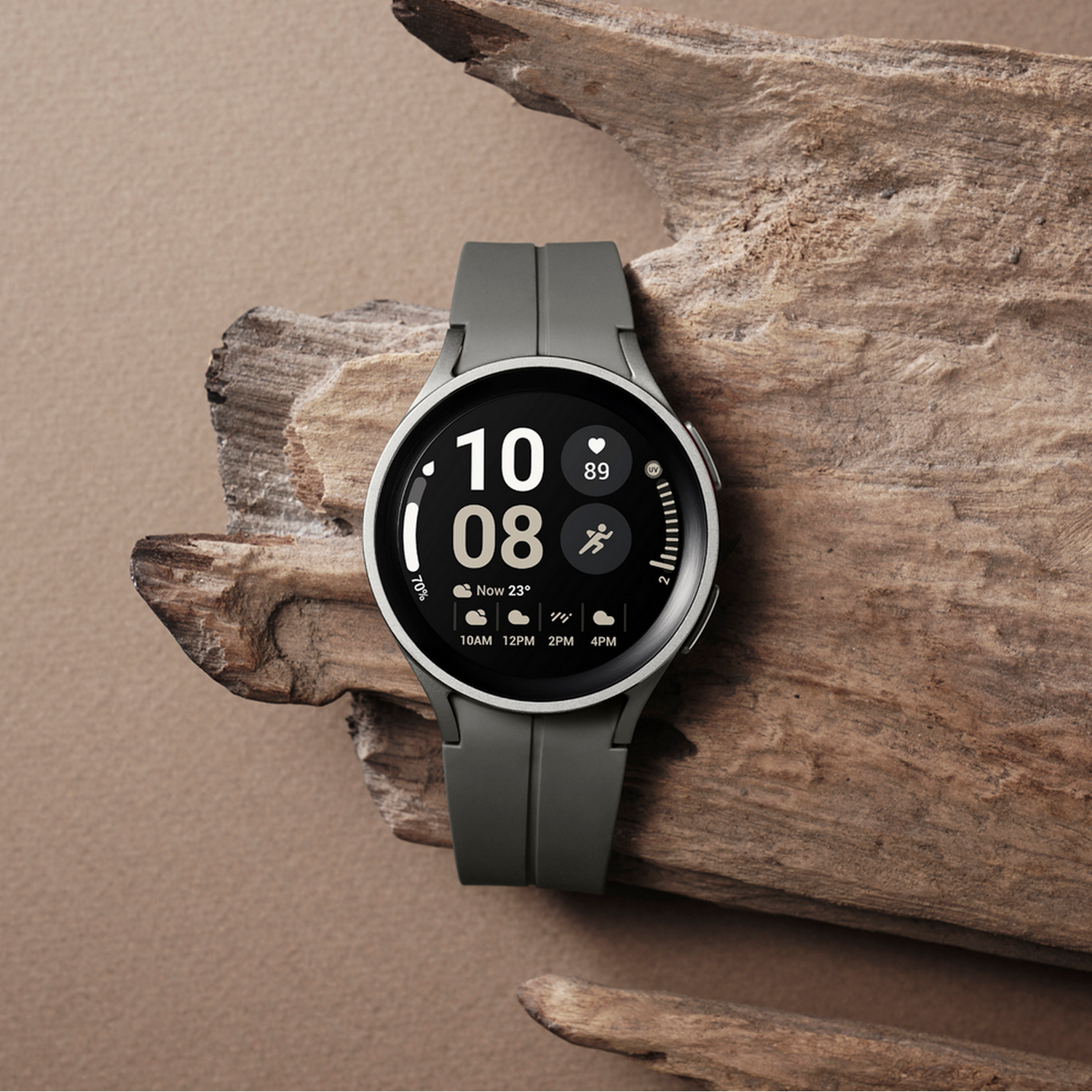 Uno smartwatch grigio su legno. Lo schermo mostra ora, data, percentuale batteria e icone attività.