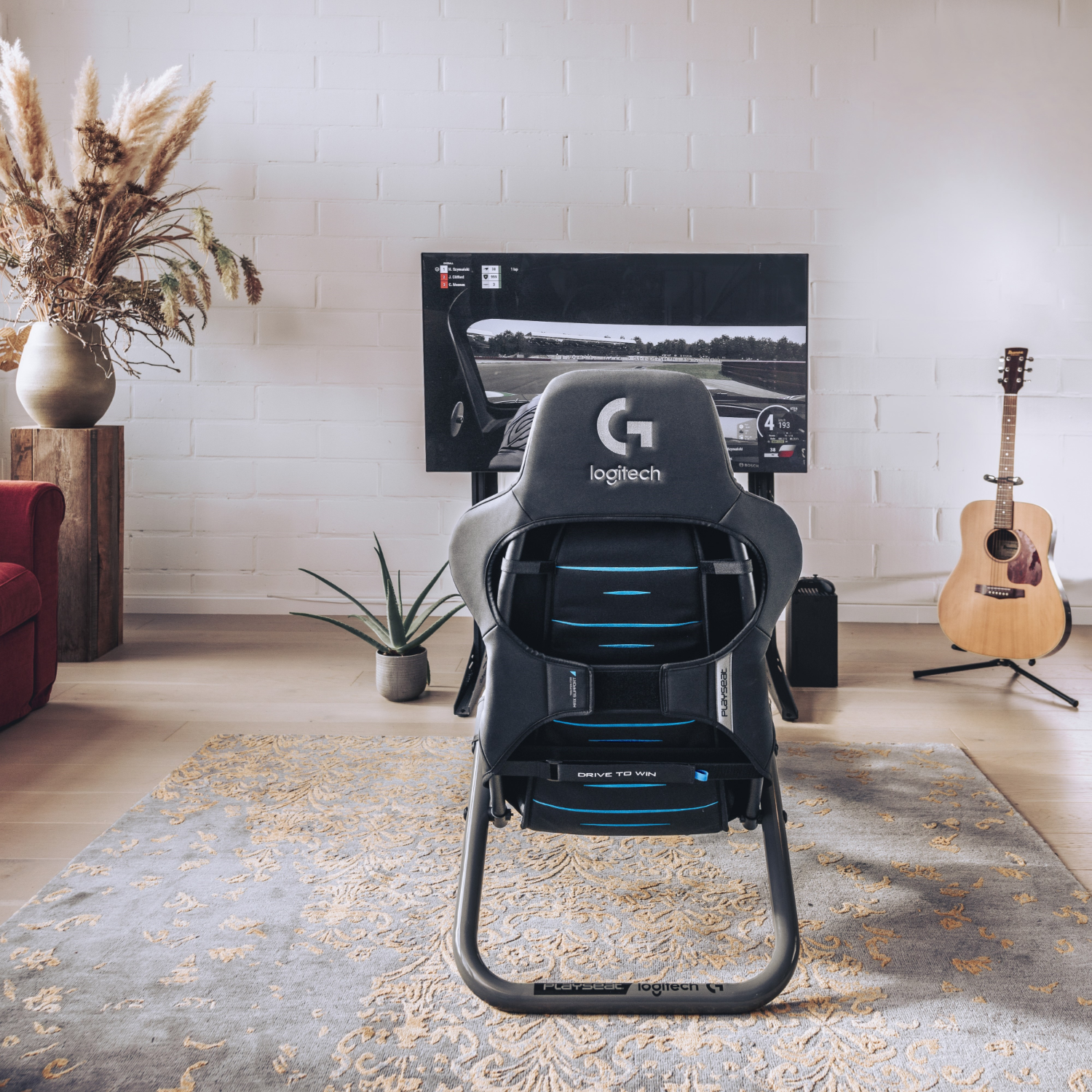 Gaming-Stuhl in einem Wohnzimmer mit einem Fernseher, der ein Rennspiel spielt, Gitarre und Trockenblumen.