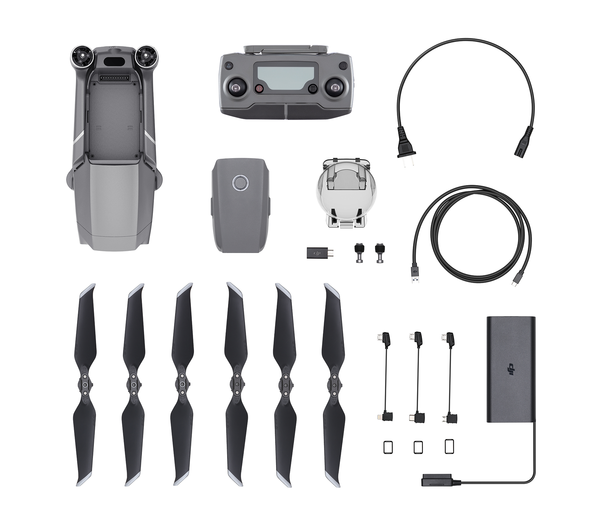Drohne und Zubehör, darunter Propeller, Fernbedienung, Akku und Kabel, vor weißem Hintergrund angeordnet.