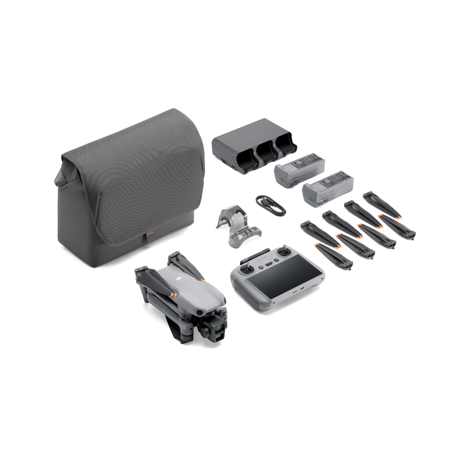 Dron z pilotem, bateriami, etui i akcesoriami na białym tle.