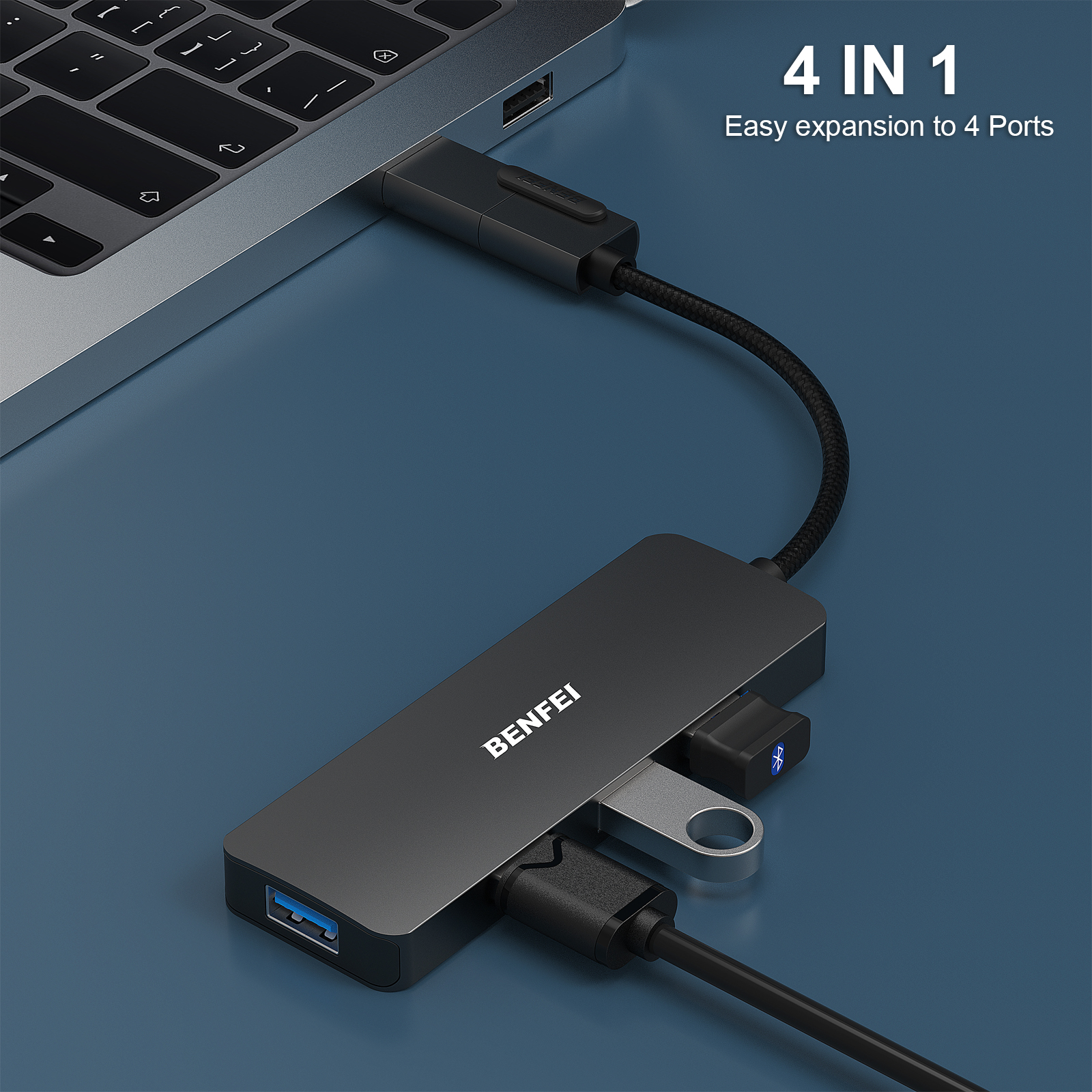 Ein schwarzer Hub, der über ein schwarzes Kabel mit einem Laptop verbunden ist, mit USB- und USB-C-Anschlüssen und einem silbernen USB-Stick.