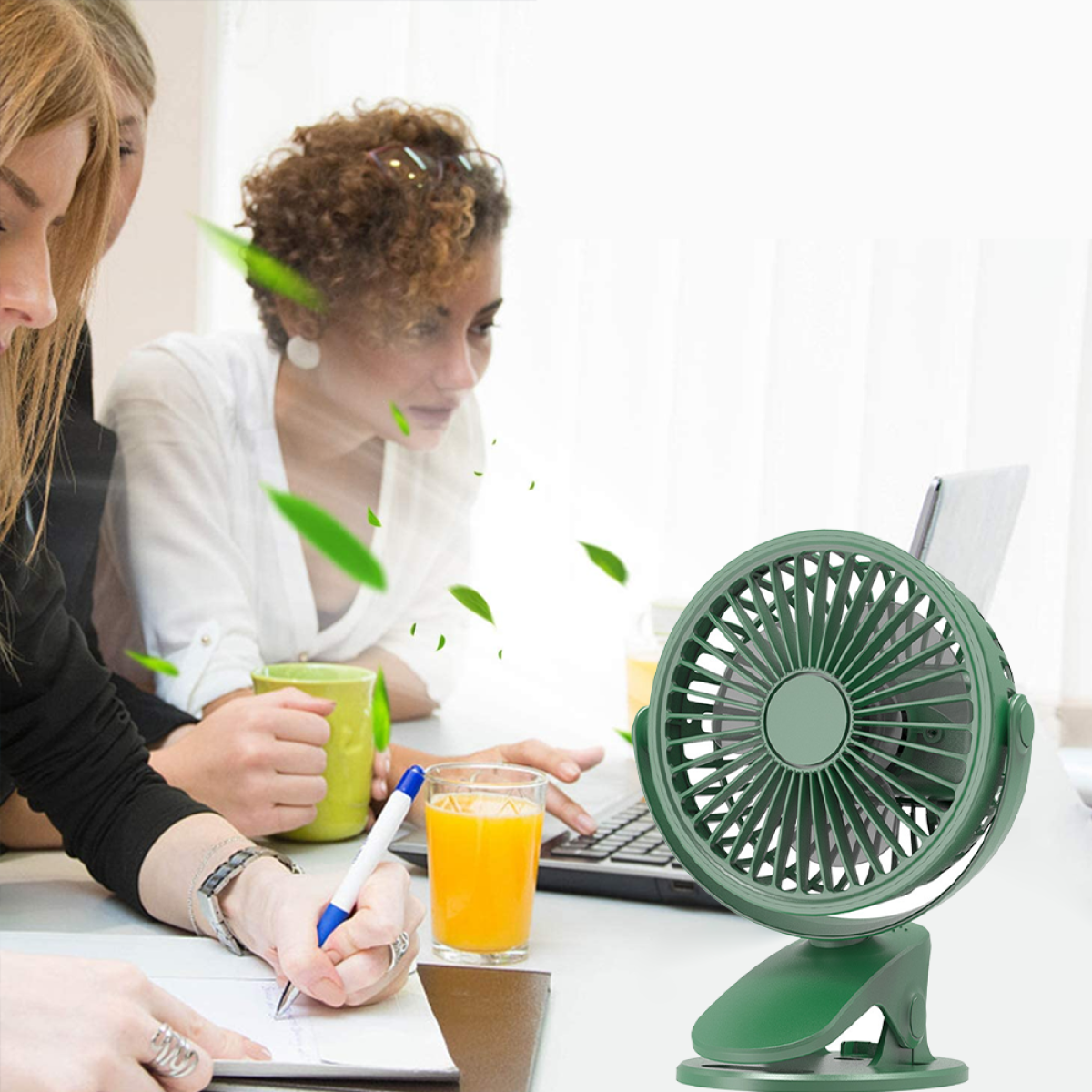 Zwei Frauen und ein Mann benutzen einen Laptop mit einem grünen Ventilator.