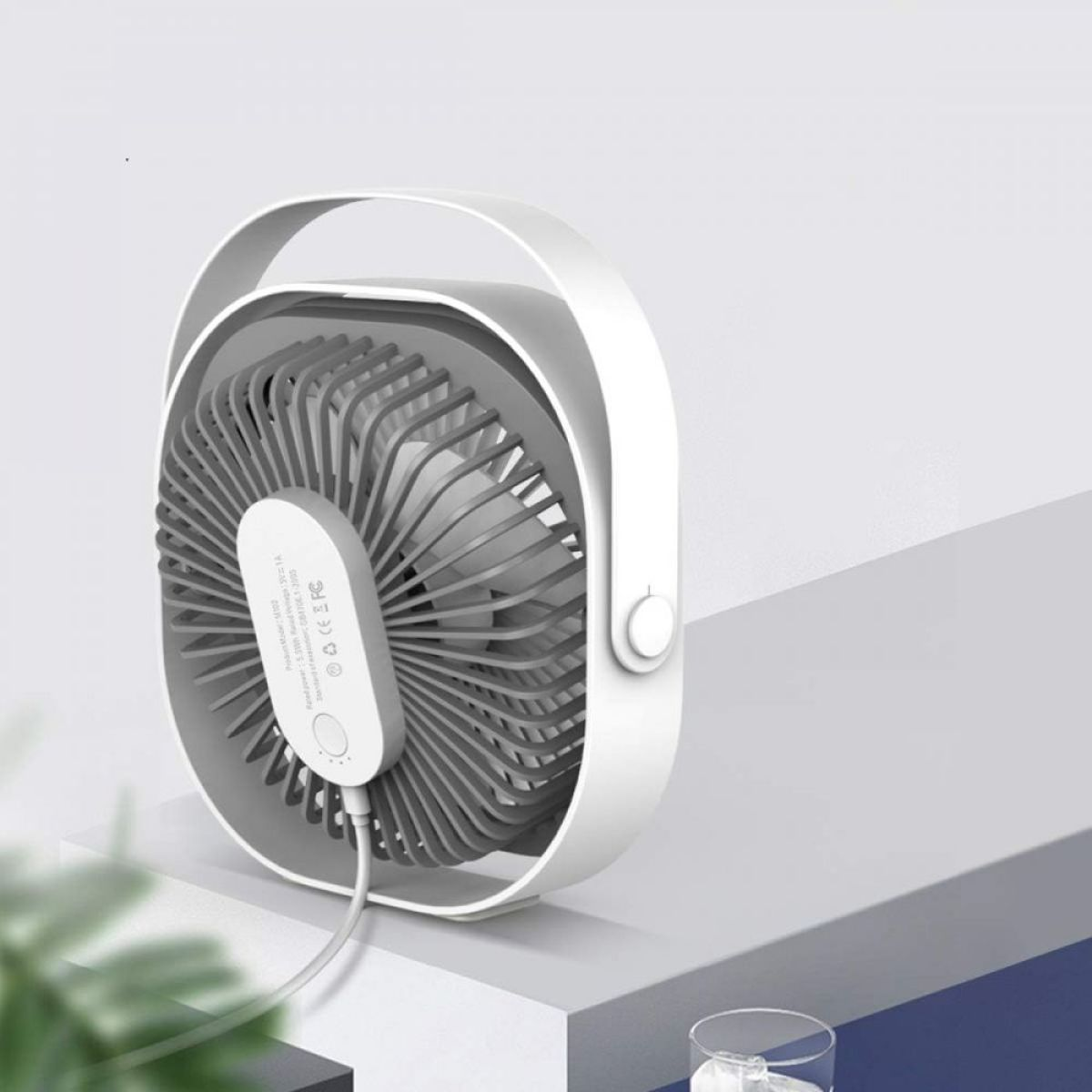 Ein weiß-grauer Schreibtischventilator auf einer weiß-grauen Oberfläche. Weißer Hintergrund.