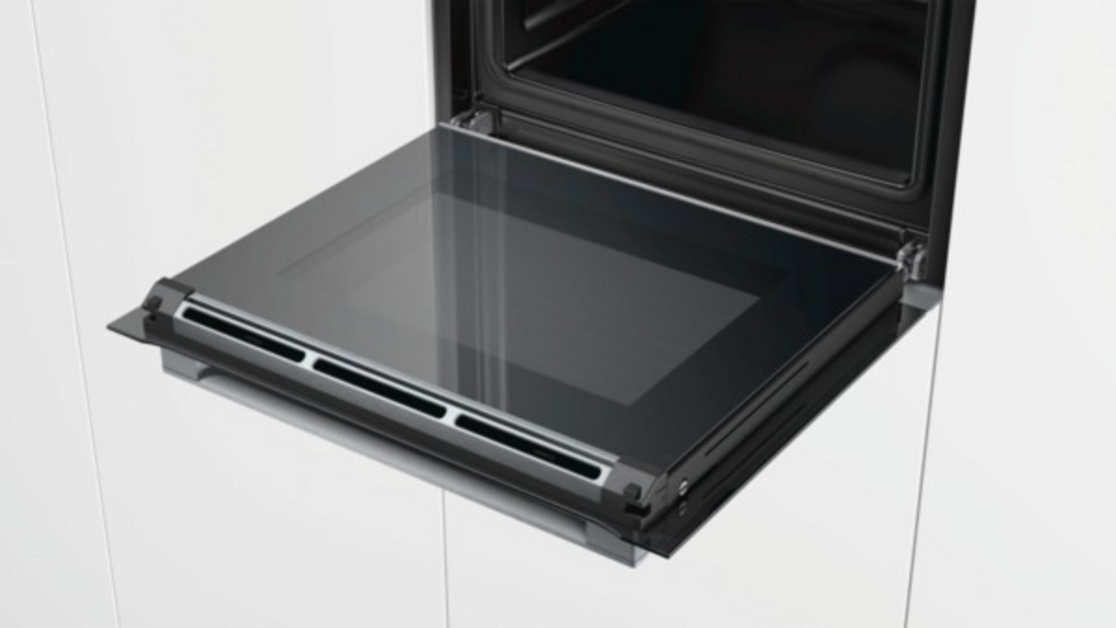 Un four ouvert avec une porte vitrée, visible de l'intérieur.