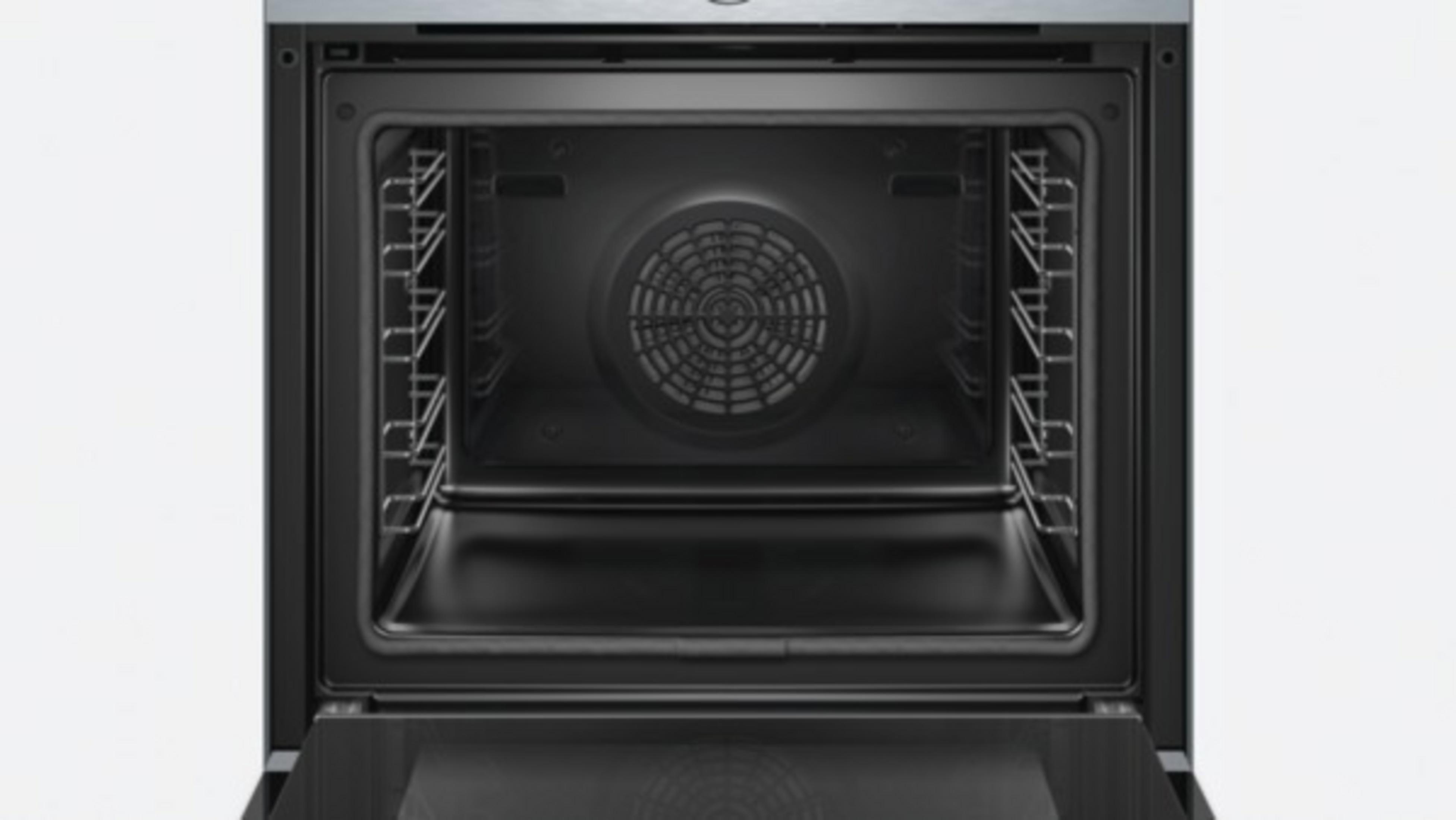 Intérieur d'un four avec des grilles et un ventilateur, la porte est ouverte.