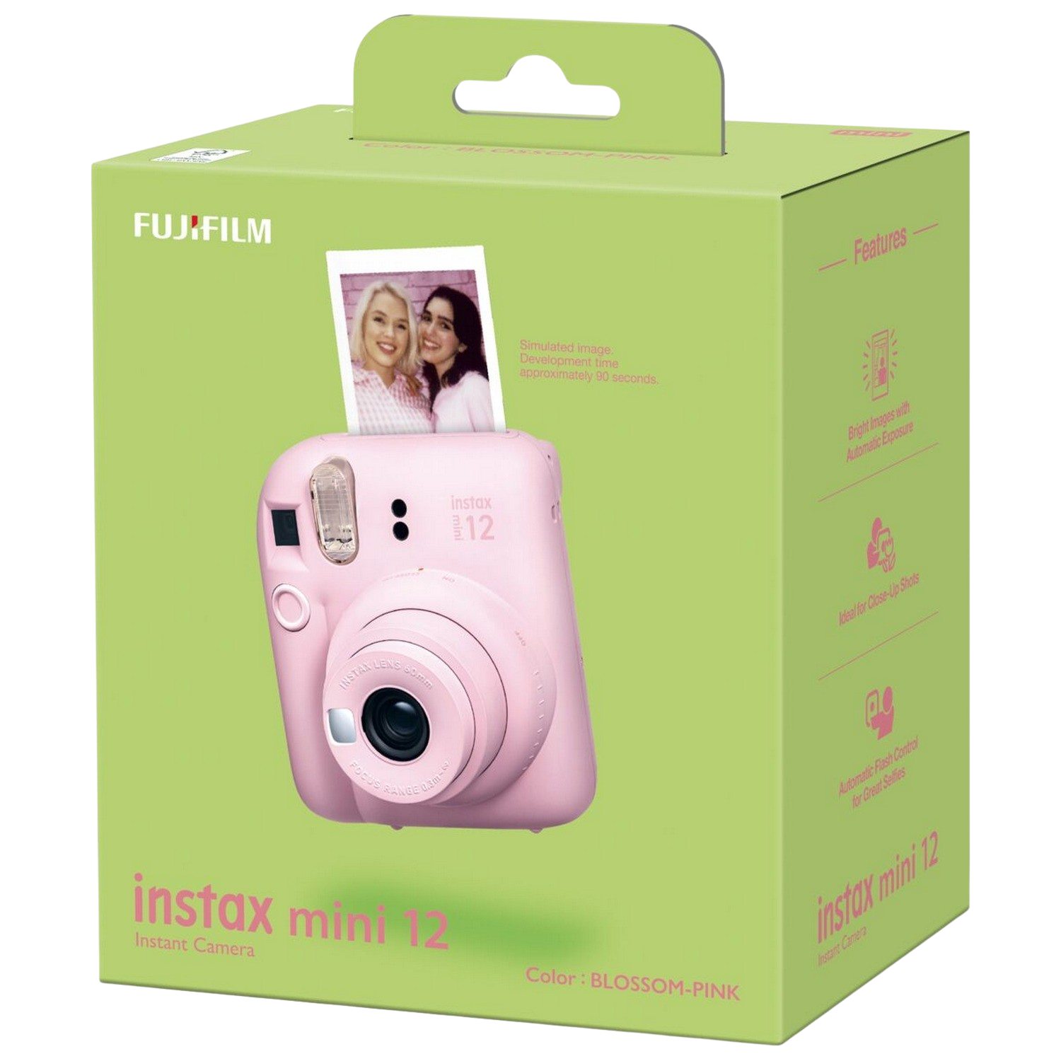Roze instantcamera in een groene doos. Een foto is zichtbaar bovenop. Witte achtergrond.