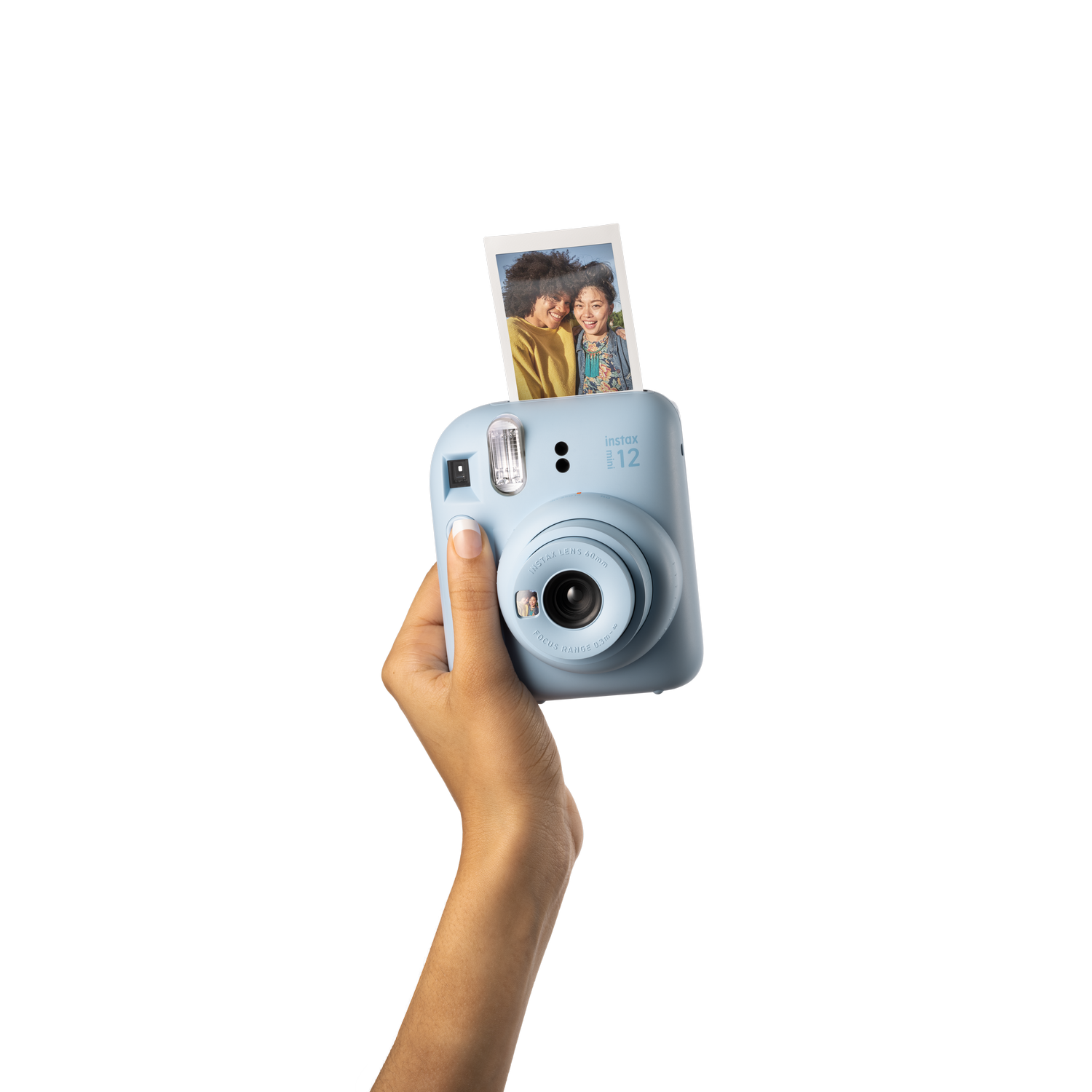 Bir el tarafından tutulan açık mavi Instax kamera. Bir fotoğraf çıkarılıyor. Siyah zemin.