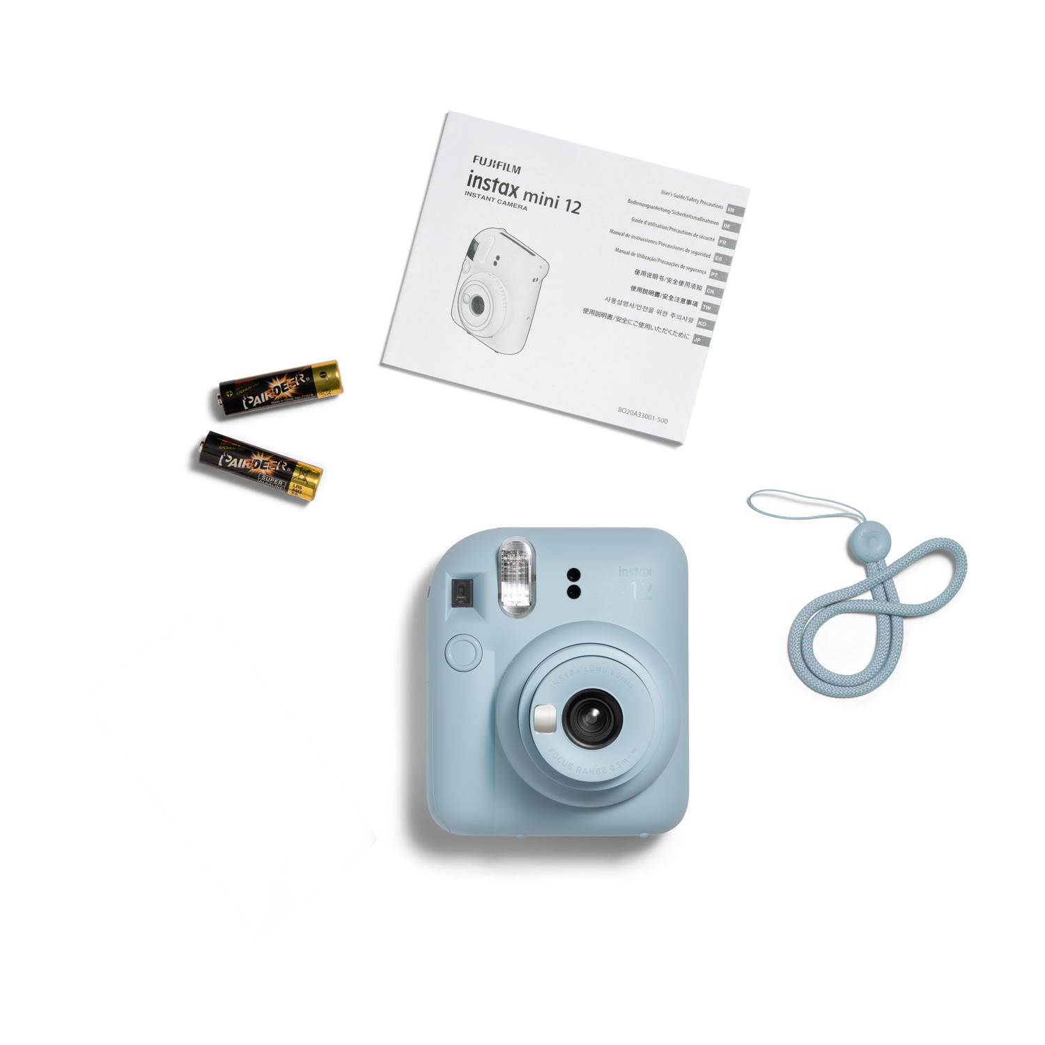 Aksesuar olarak piller ve bilek kayışı gibi aksesuarlara sahip açık mavi instax mini 12 kamera.
